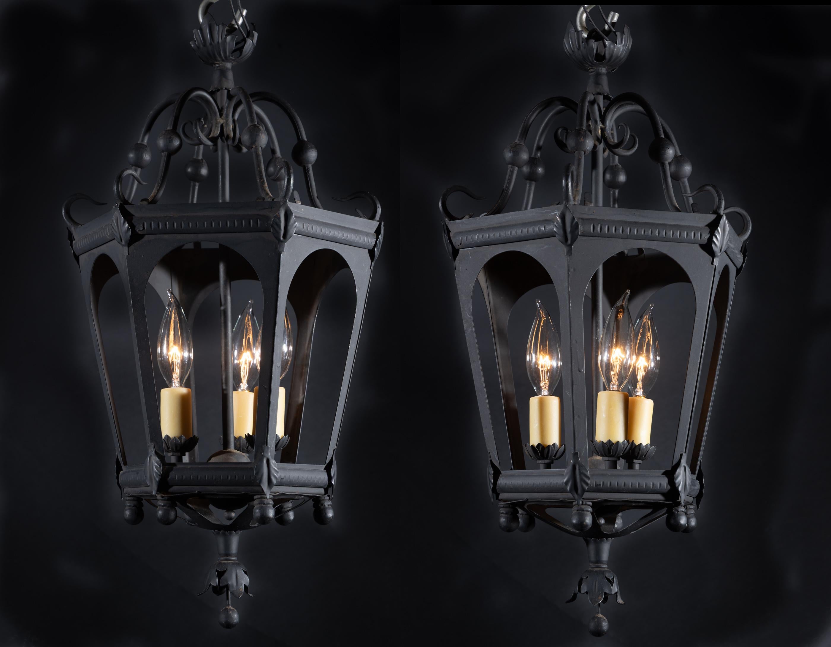 Este fantástico farol de estilo gótico es de hierro pintado y data de mediados del siglo XX. El farol presenta seis paneles abiertos y una sencilla corona floral. El vástago central soporta tres luces, y está unido al cuerpo por unos bonitos brazos