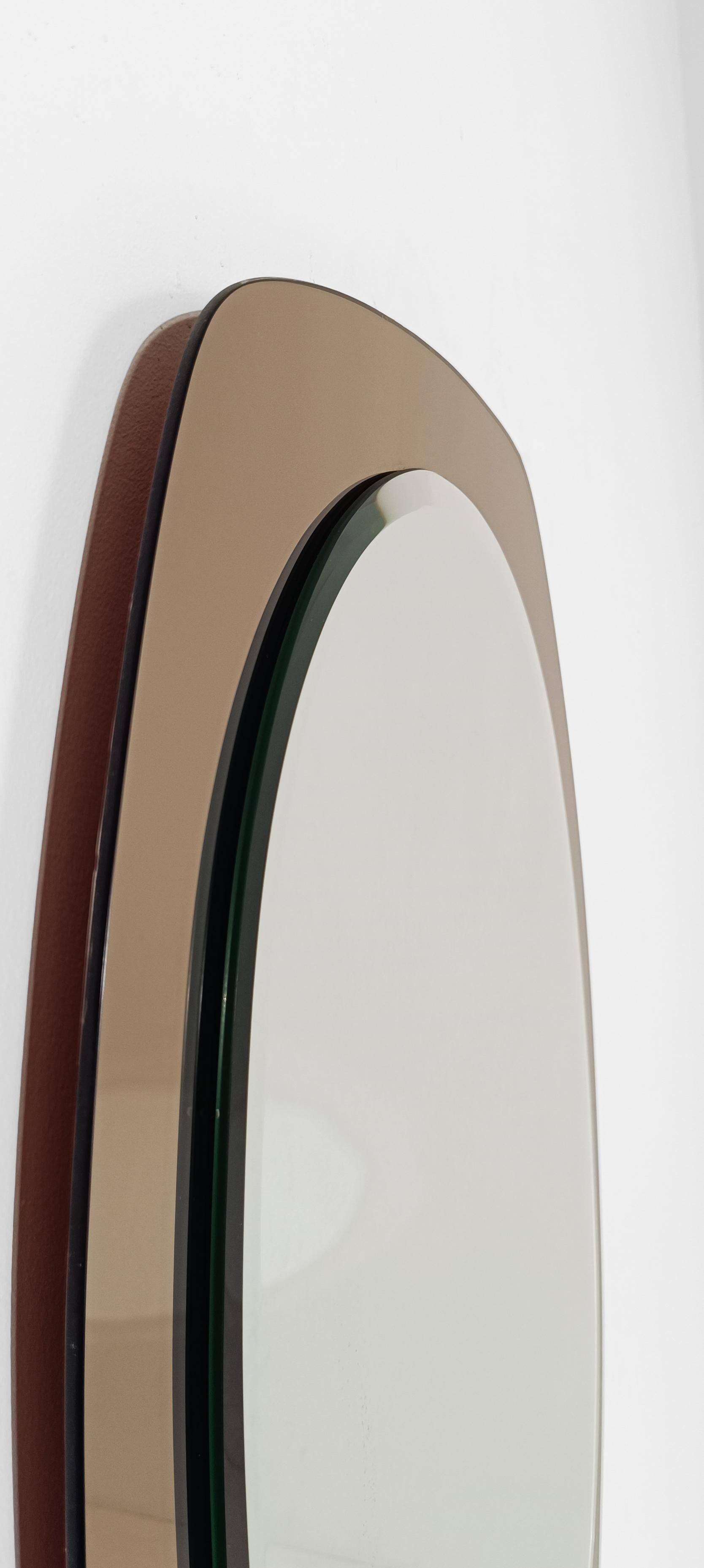 Je propose à la vente un élégant miroir fabriqué en Italie vers les années 70.
La forme est essentielle et raffinée, un miroir ovale biseauté superposé et contenu par un cadre en verre couleur bronze rose,
grâce à l'application d'une fine couche