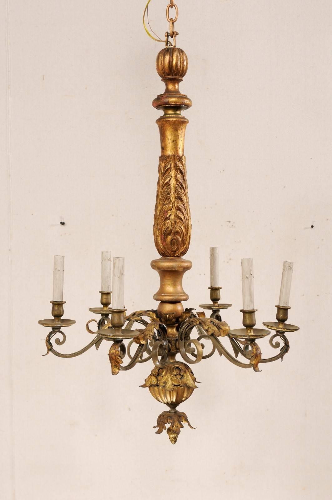 An Italian six-light carved wood center column and metal chandelier. This handsome mid 20th century Italian chandelier features a nicely carved acanthus leaf wrapped center column, and an iron decorated ball with leaf motif finial suspended below.