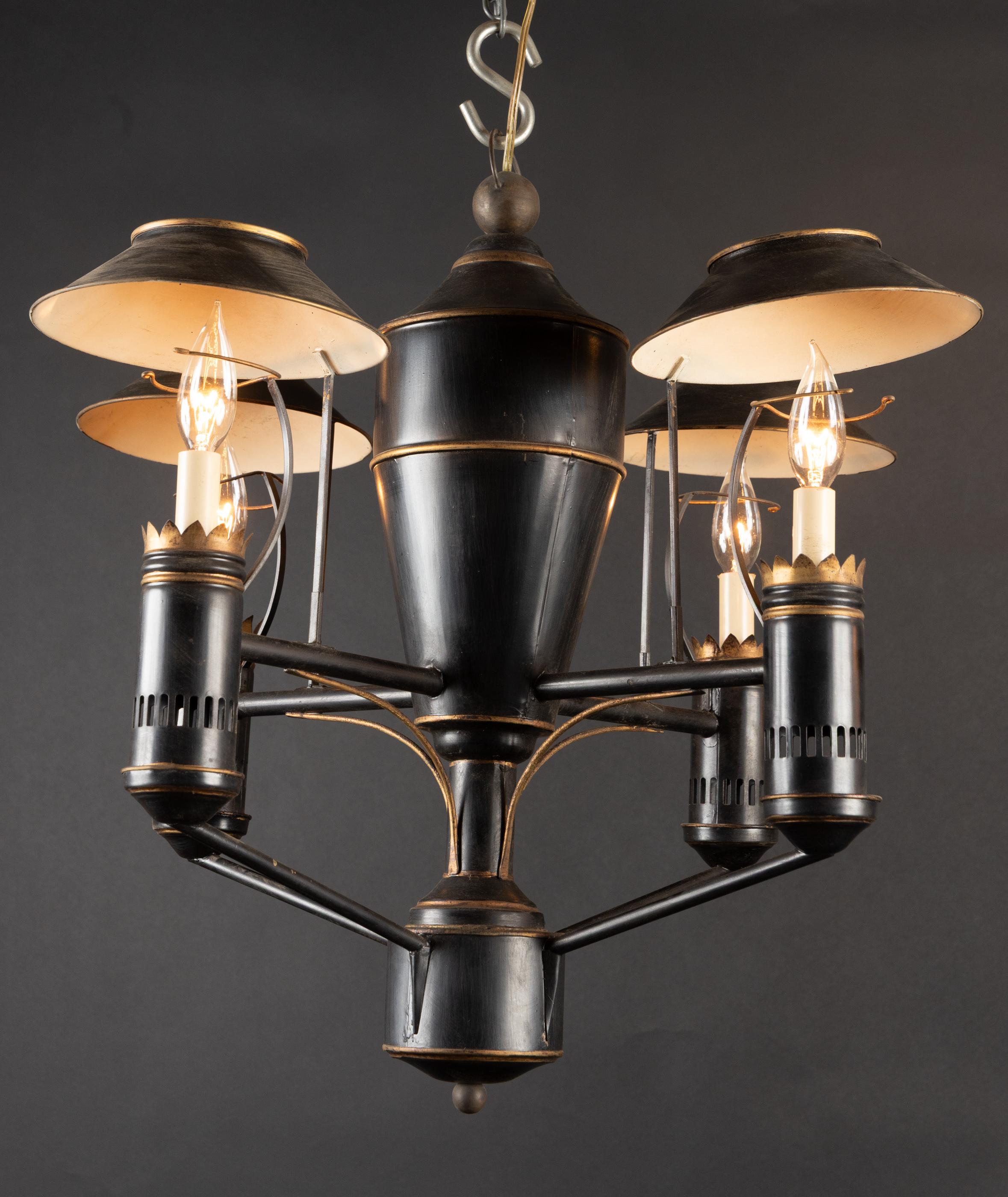 Bellissimo lampadario italiano della metà del XX secolo in nero e oro con paralumi in tole. Il lampadario è dotato di quattro luci, ognuna delle quali è sostenuta da bobeches di tole traforate.   Il centro sostanziale a forma di vaso si abbina bene