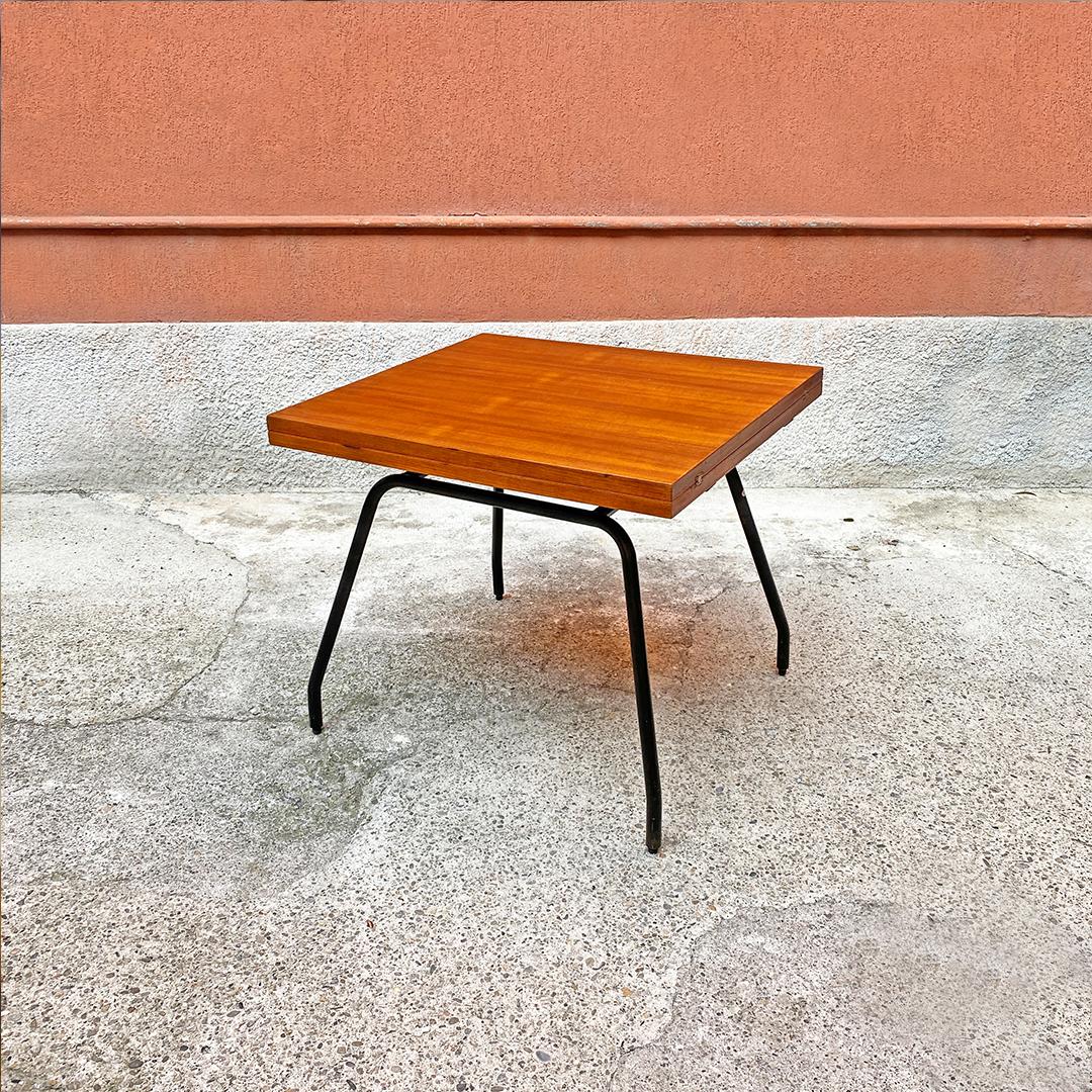 Italian Mid-Century Modern metal and wood extendable table, 1960s
Almost square shaped table, with folding top in solid wood placed on two guides, which doubles the size of the surface and legs in black metal, with round section.
1960