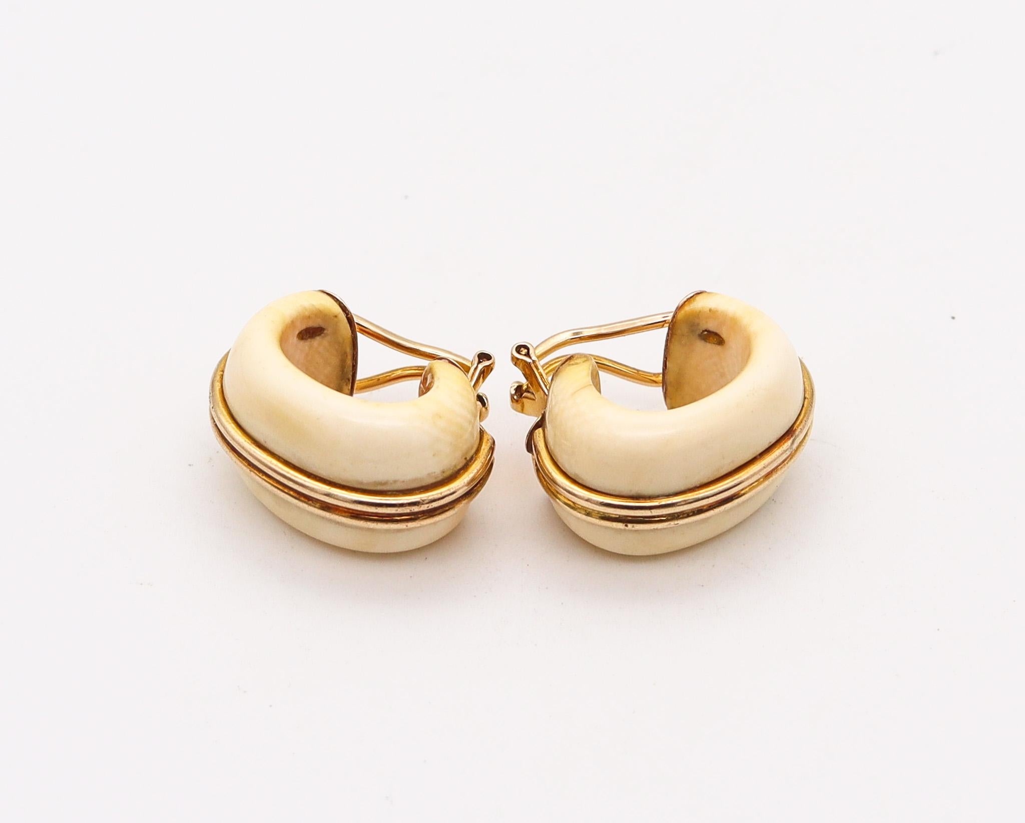 An Italian modernist hoop earrings.

Vintage modernist pair of hoop earrings, created in Italy back in the 1970. They was crafted with solid yellow gold of 14 carats and mounted with natural carvings. Fitted with hinged French omega backs for