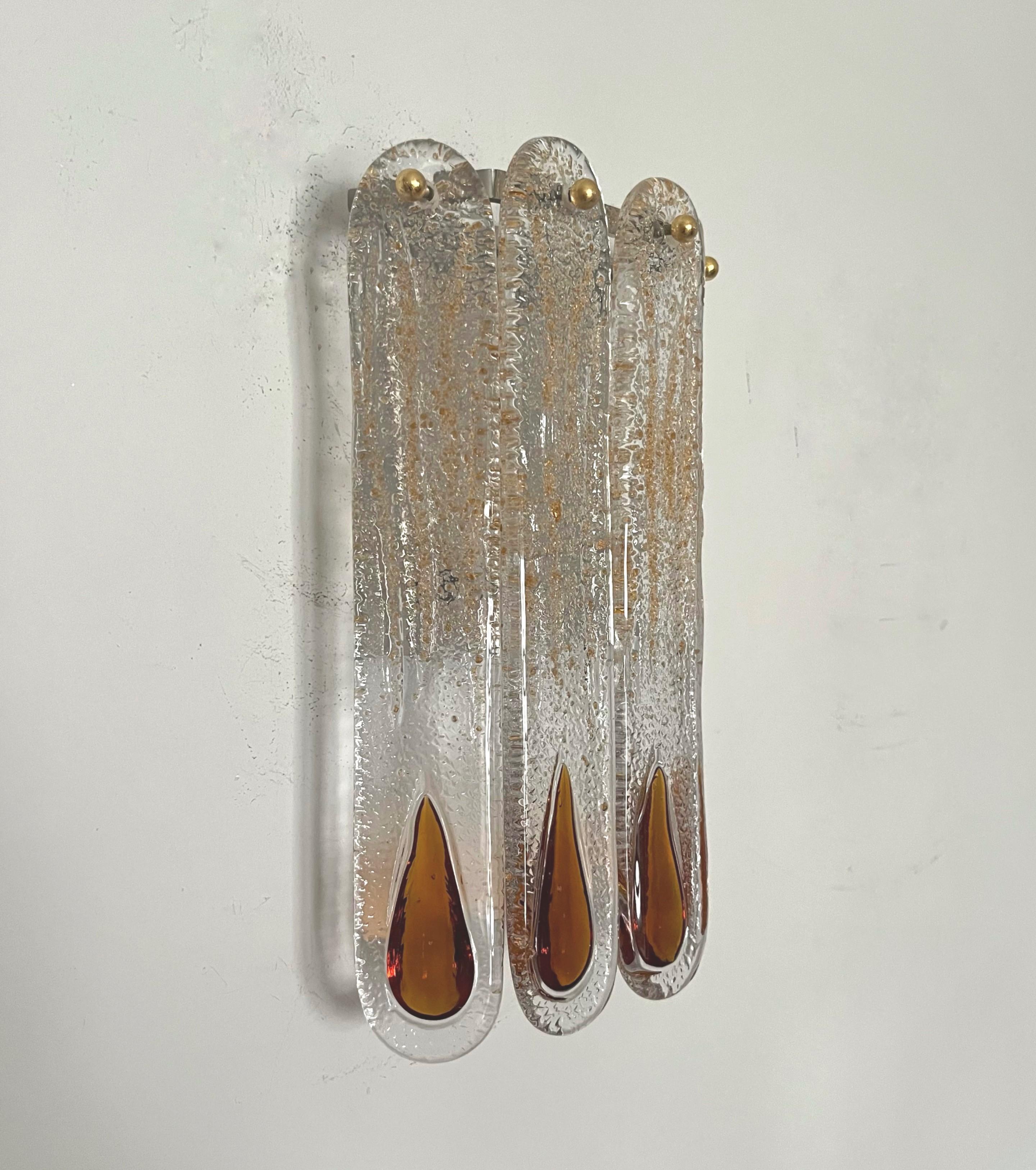 Unique and beauty Italian Amber Murano glass Wall Sconce from 1970s. This fixture was designed and manufactured during the 1970s in Italy by Mazzega.
This Wall Sconce is equipped with 2 light sockets E14. A professional electrician has checked and