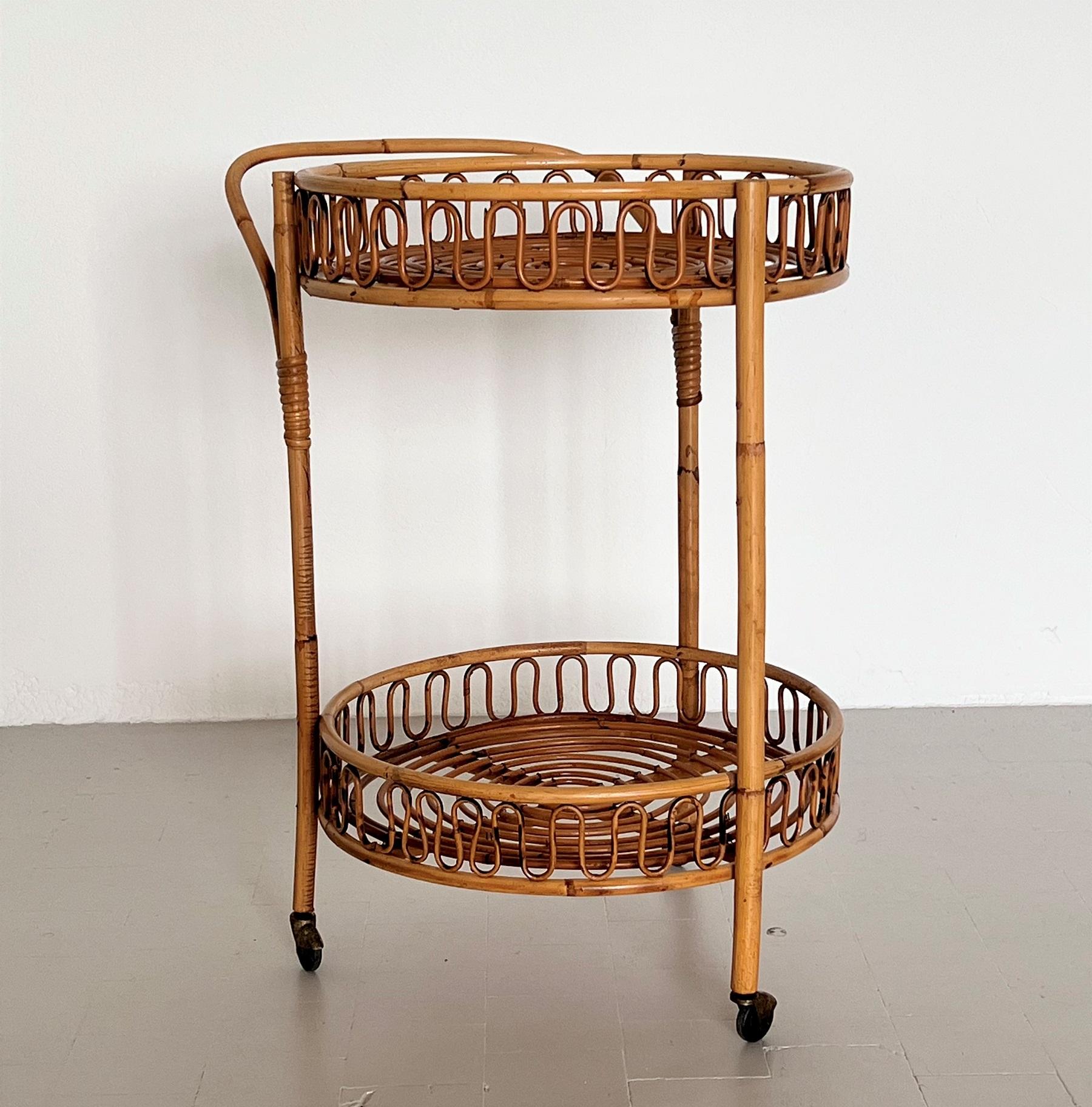 Gorgeous bar cart or trolley made of curved bamboo and rattan during the Italian mid-century in the 1970s.
The cart is circular with two tiers, handle, and 4 rollers. 
The four rollers are rolling smoothly.
Beautiful original and very good cleaned