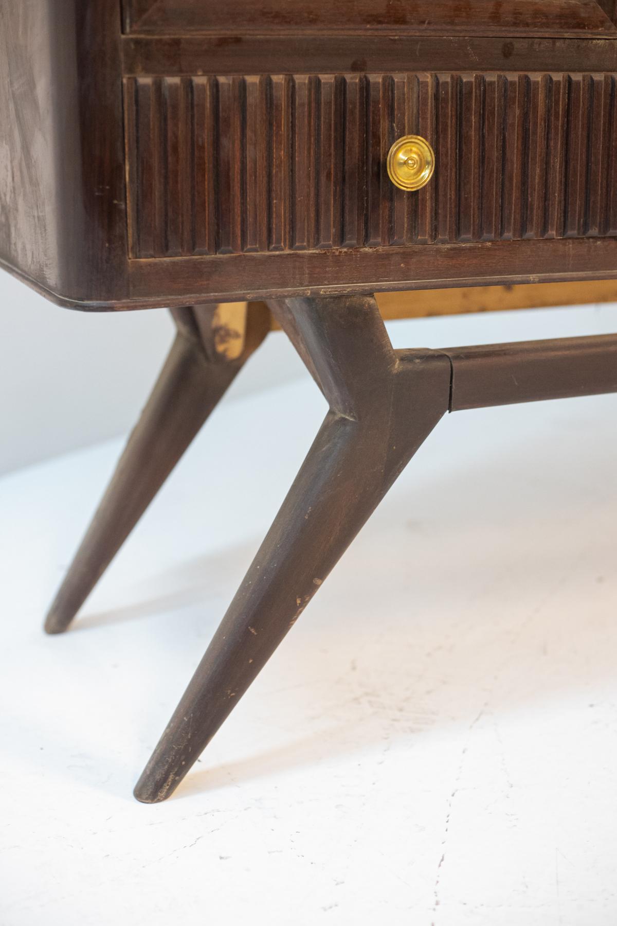 Beautiful wooden bar cabinet of fine Italian manufacture dating back to the 1950s.
The bar cabinet is entirely made of dark precious wood of a quite geometric and classic shape, very elegant.
There are 4 legs supporting the structure, flared and