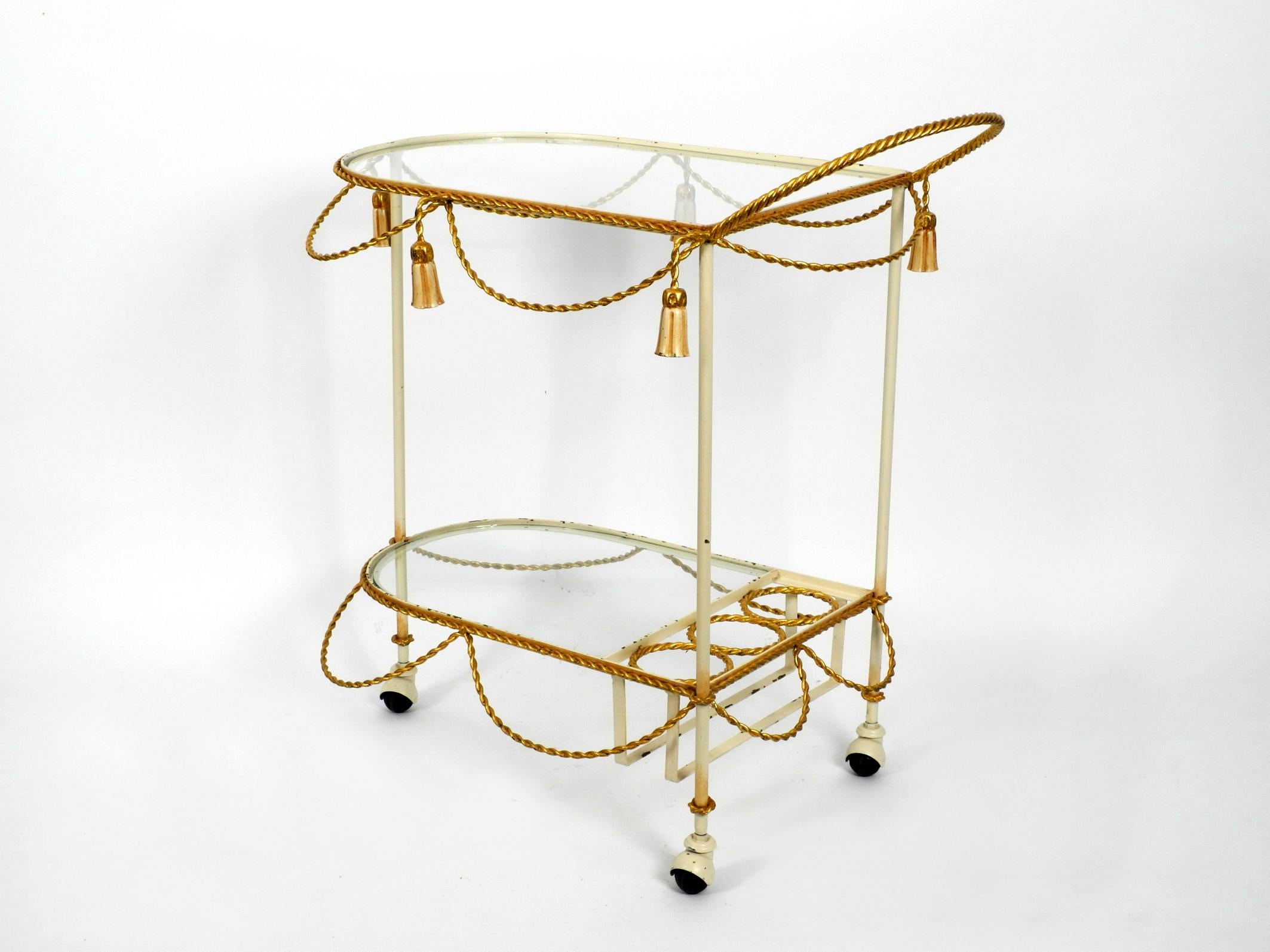 Very rare Italian Mid-Century Modern bar cart made of metal and glass. 
Great fancy design in Hollywood Regency style.
Entire metal bar cart frame is golden and beige. Very high quality, solid and heavy built.
Shelves are made of thick glass.