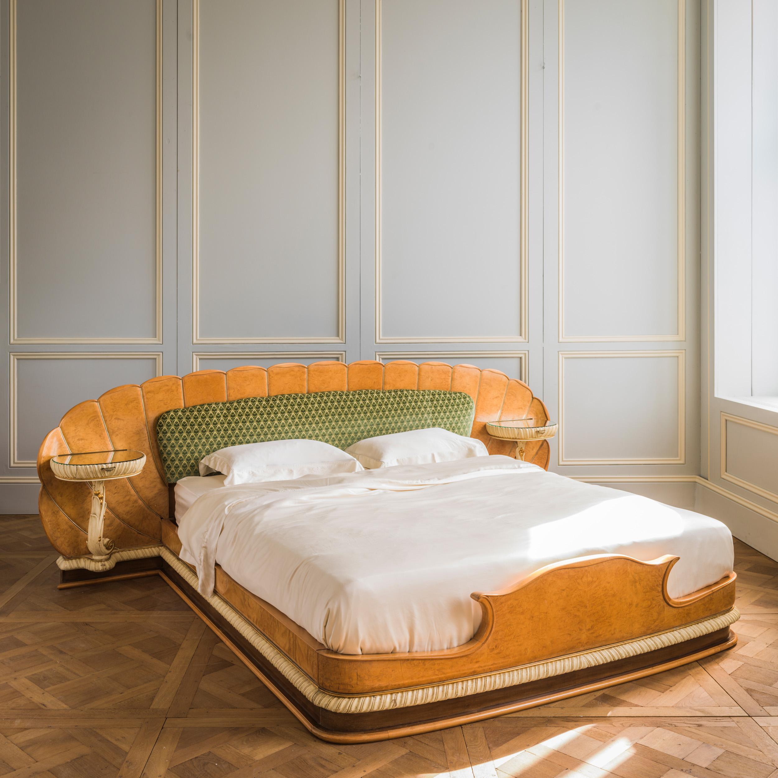 A stunning Italian bed, circa early 1940's, inspired by the Milanese designer, Giovanni Gariboldi. The bed features an Art Deco scalloped headboard with built in, curvaceous bedside tables, finished in a striking blond, burr elm, wood veneer with