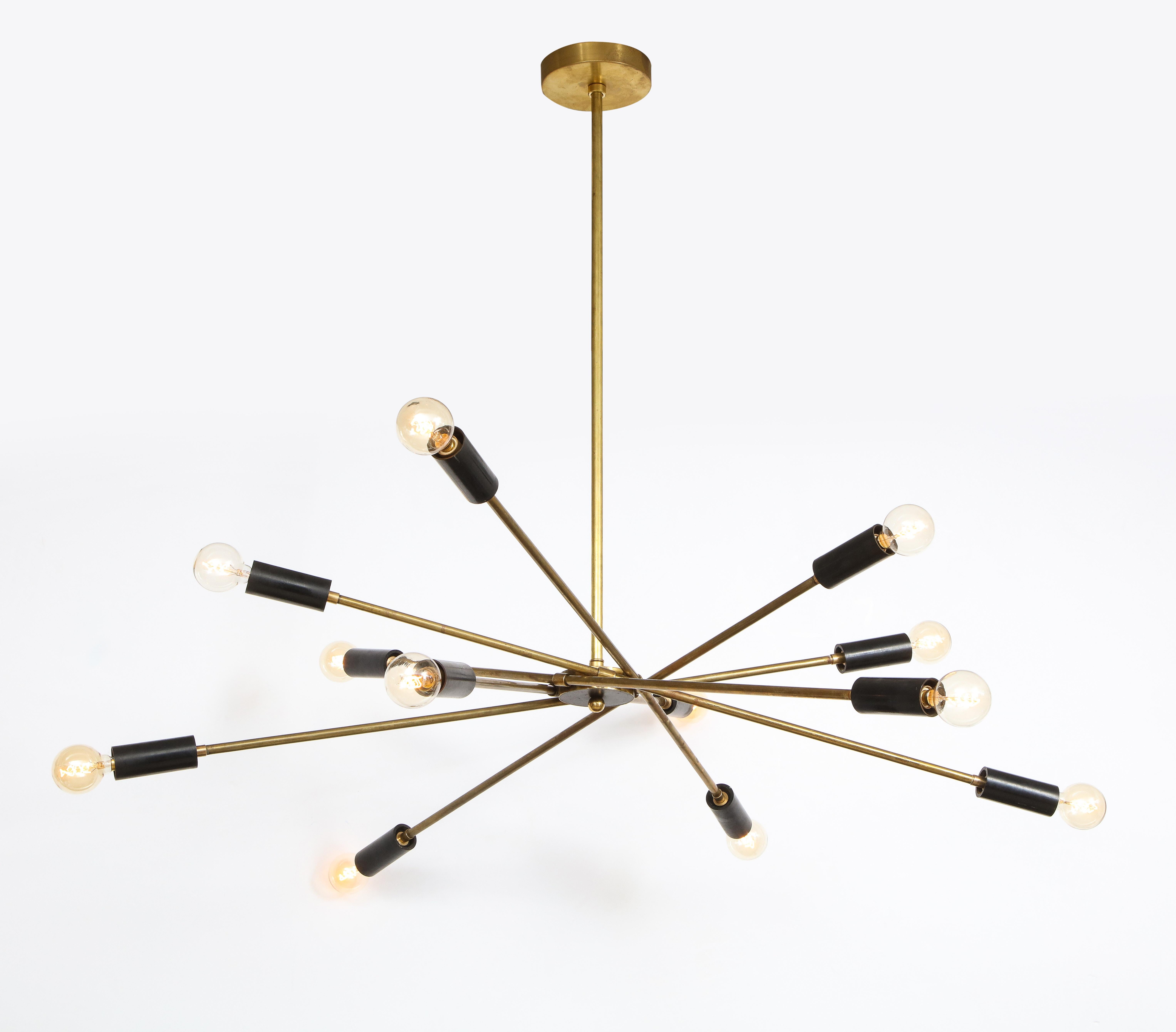 Stunning Italian Mid-Century black and brass sputnik chandelier.

This unique and sculptural chandelier consists of 6 artfully balanced brass arms with blackened candelabra sockets on either end, amounting to 12 lights total. This particular model
