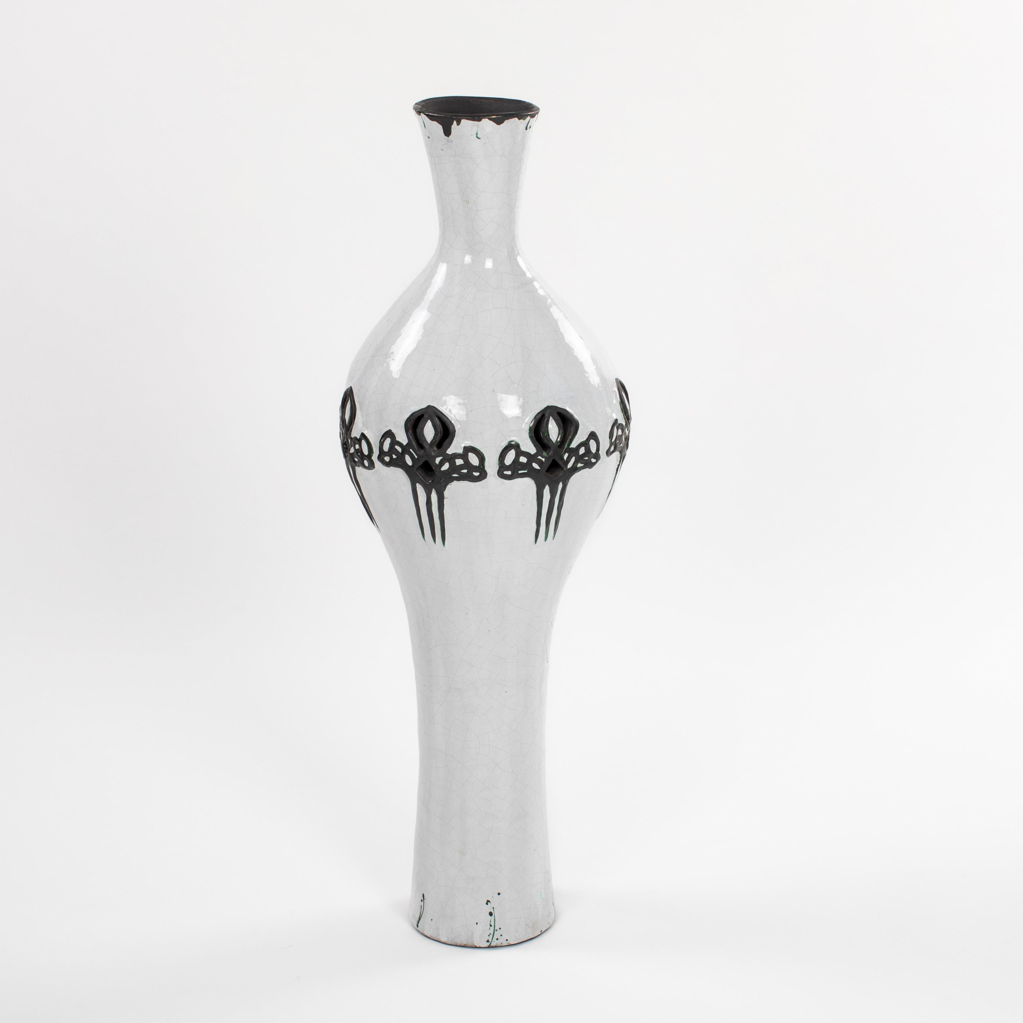 
Elegante vaso da terra vintage in tecnica raku e perforazione con decorazione a contrasto in nero. 
Collo lungo con gambo centrale bulboso e piede lungo. Un motivo a tre fori circonferenziali è stato lavorato nella parte superiore del ventre, poi è