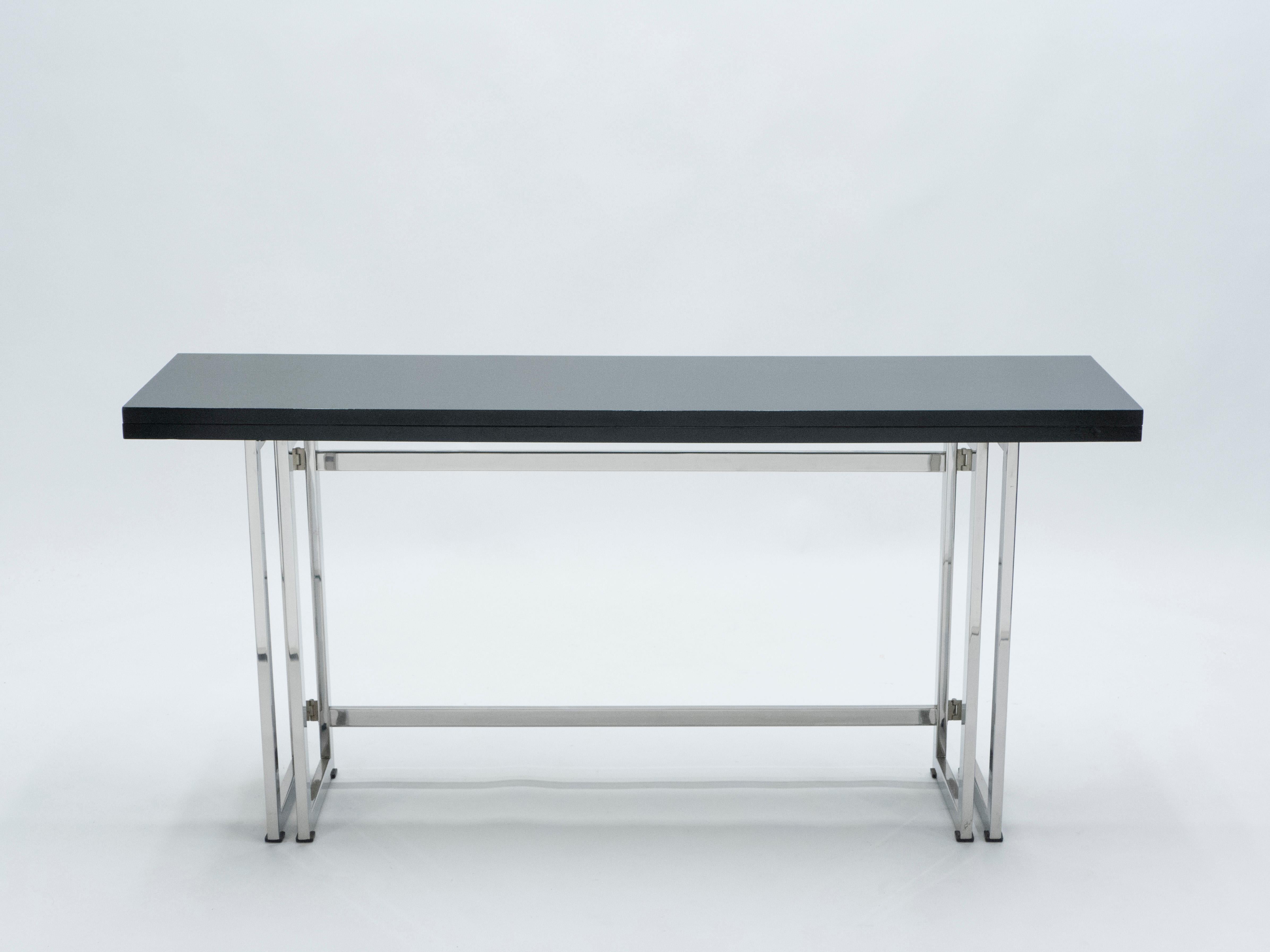 With a beautiful black lacquered top, sharply geometric chrome metal legs and a foldable body to fit your particular spatial needs, this mid-century italian console table by Artelano carries a stellar futuristic mid-century aesthetic into the