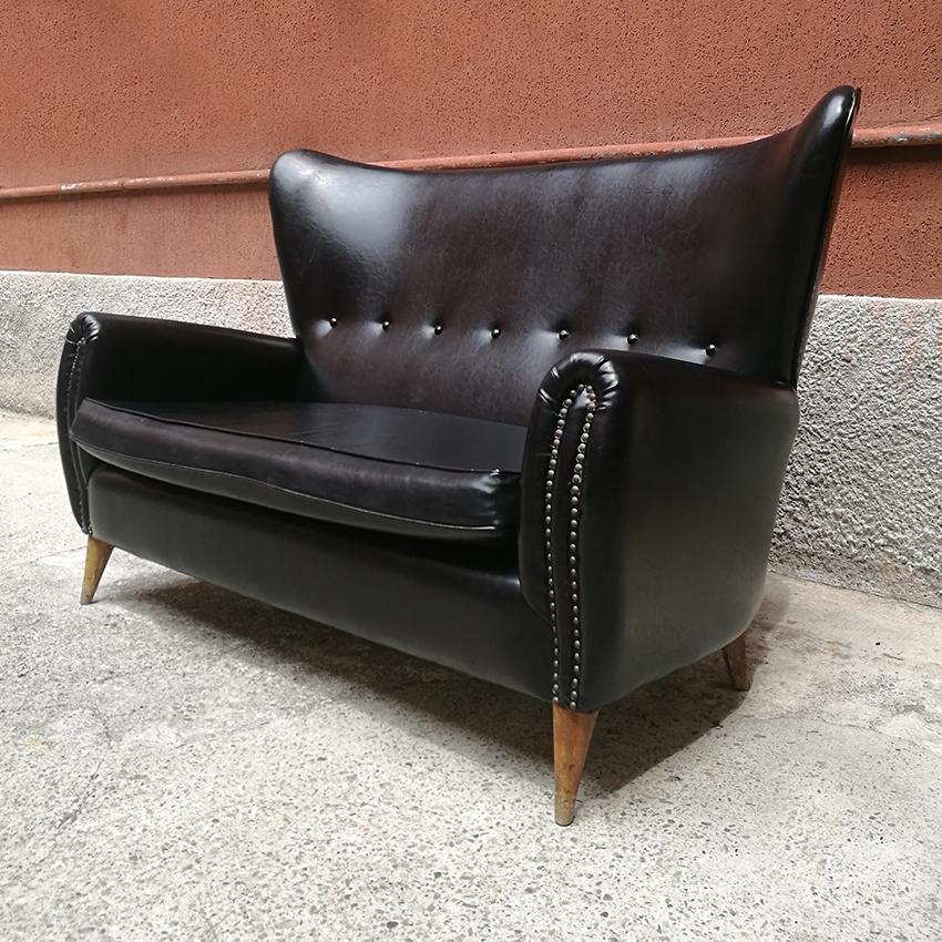 Italian mid-century black leather sofa with armrests and wooden legs, 1950s
Sofa in black leather, with armrests, central stitching on the back, with small brass studs on the back and wooden legs.
Perfect for homes with period furniture but also
