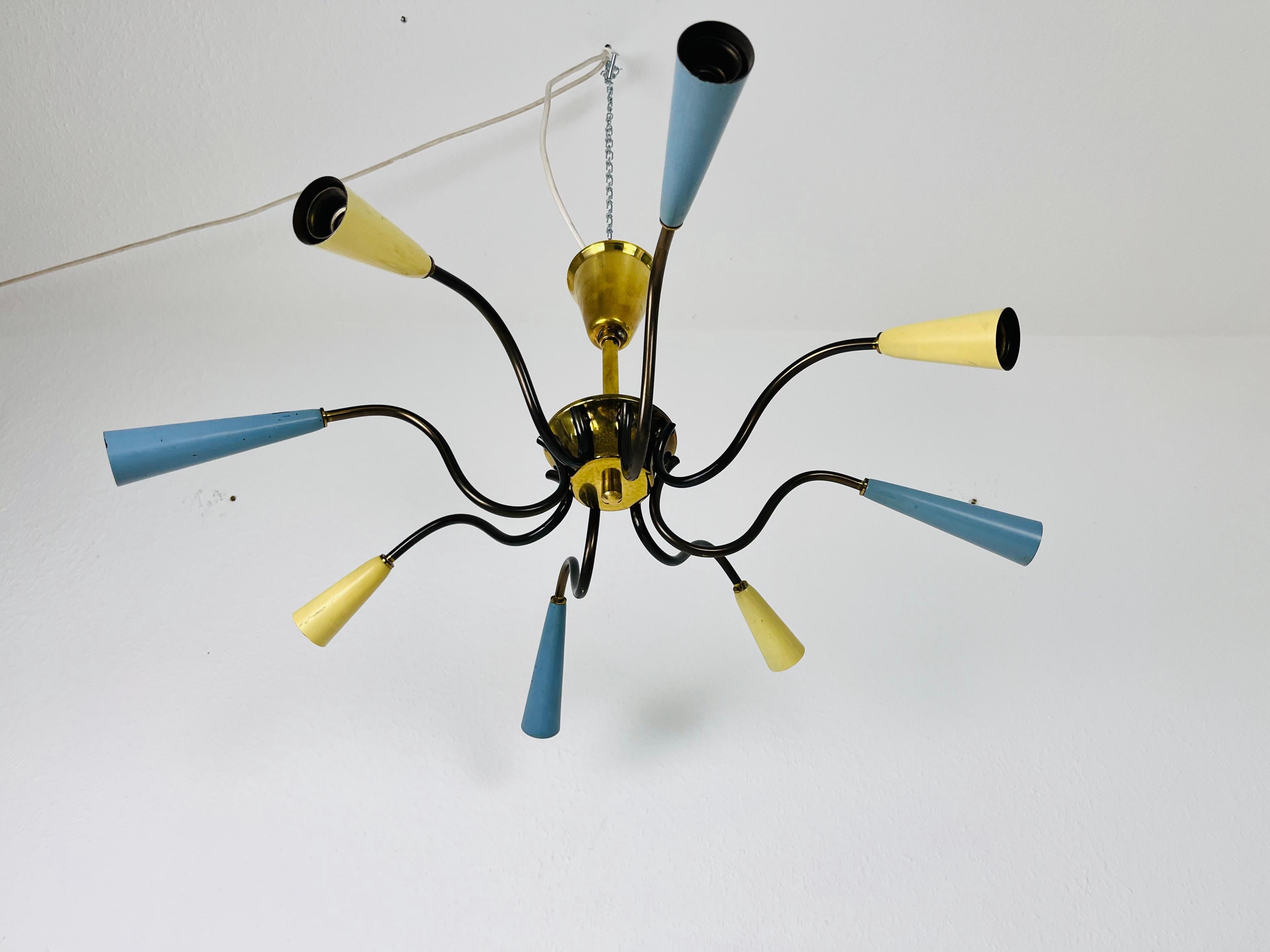 A Sputnik chandelier made in Italy in the 1960s. It is fascinating with its eight blue and yellow arms, each of it with an E14 light bulb. The shape of the light is similar to a spider.

The light requires 8 E14 light bulbs. Works with both