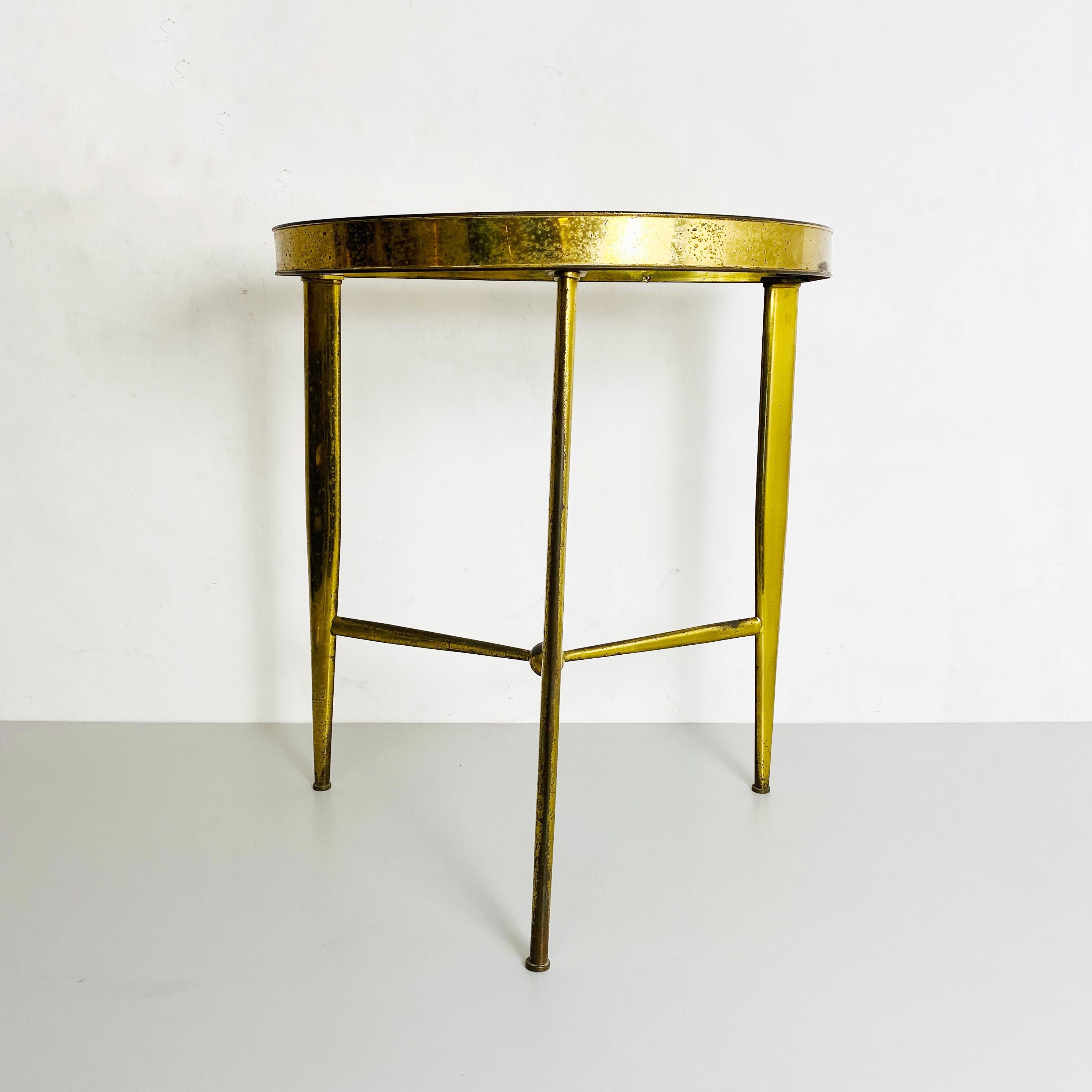Brass and glass console, 1950s.
Brass irregular shape console with three legs welded together with a central sphere and upper glass top.
1950s

Good condition, some signs of aging.

Measurements in cm 51 x 35 x 59 H.