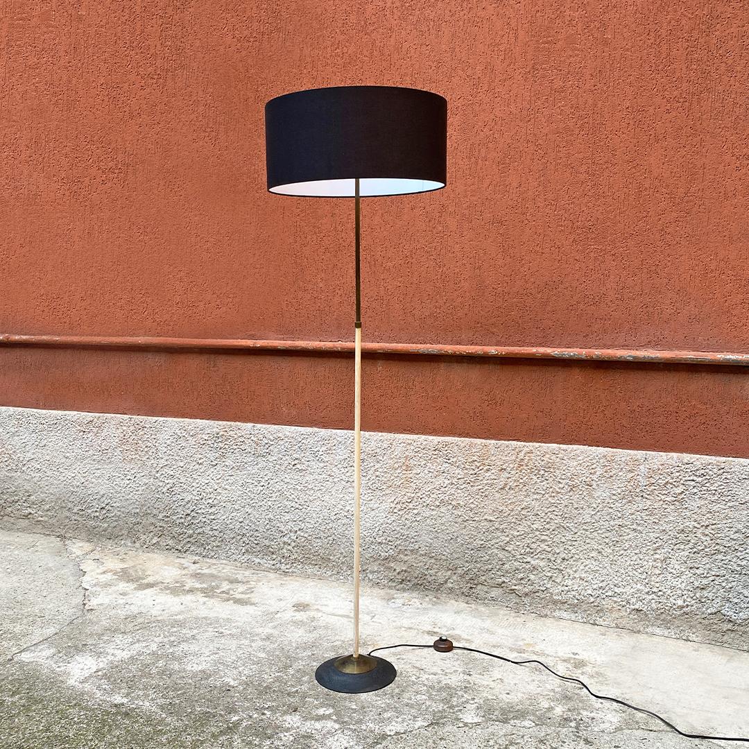 Italian mid-century brass and metal floor lamp by Stilnovo, 1950s
brass floor lamp, white enameled lower part and circular base in black metal and brass.
Cylindrical lampshade in black fabric.
Produced by Stilnovo, the brand is present.

Good