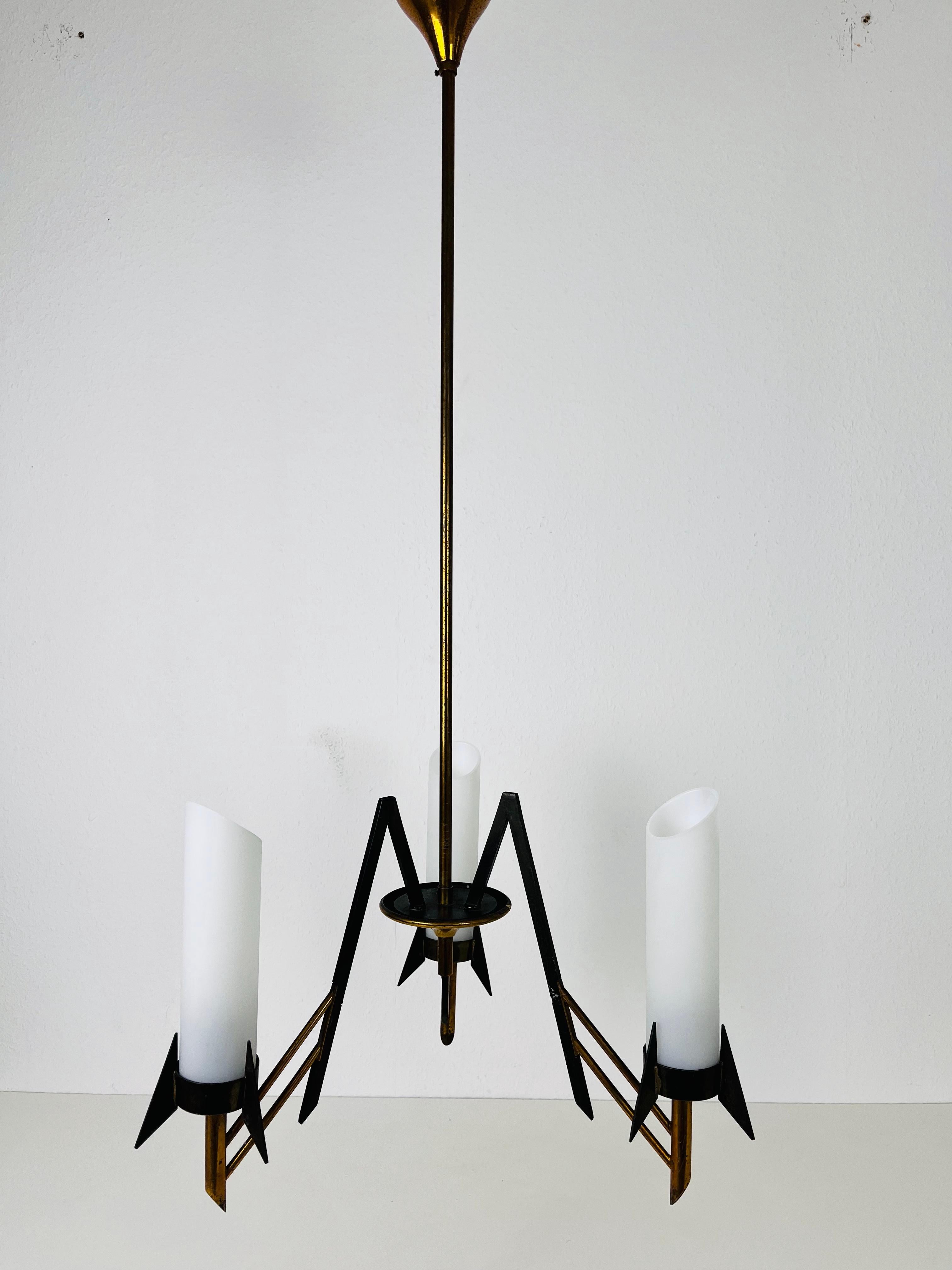An italian chandelier made in Italy in the 1960s. It is fascinating with its three arms, each of it with an opaline glass element. 

The light requires 3 E14 light bulbs. Works with both 120/220V. Good vintage condition.

Free worldwide express