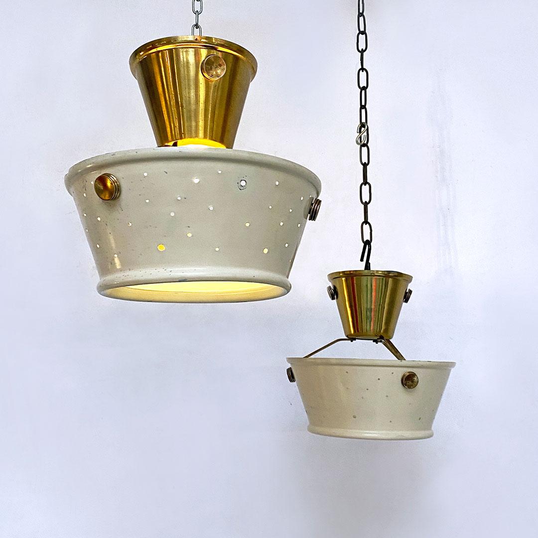 Italian Mid-Century Modern brass and cream micro perforated metal pair of chandeliers by Arredoluce style 1950s.
Chandeliers in cream-colored micro-perforated metal sheet, with upper part and details in brass and round diffuser in satin glass in