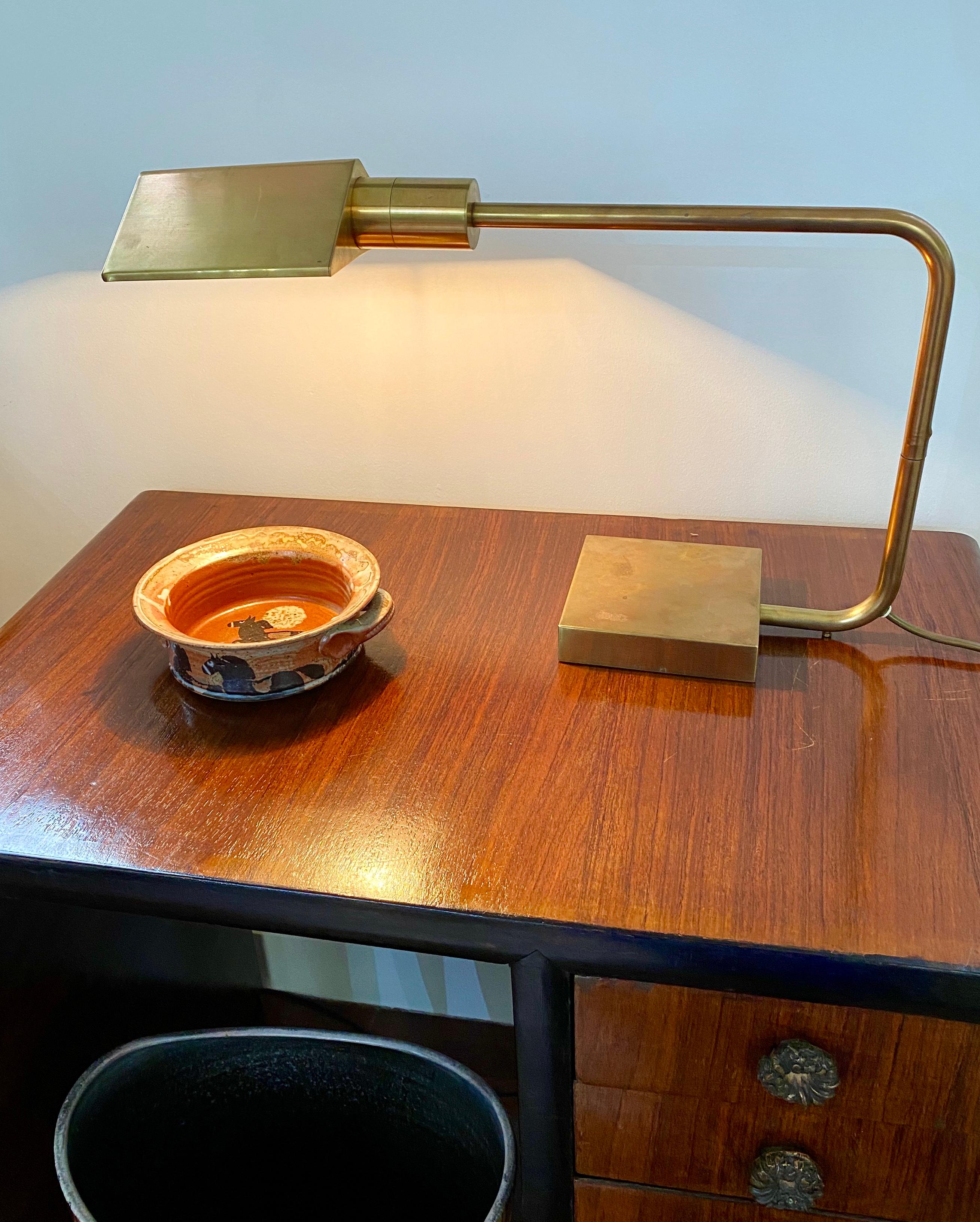 Italian midcentury brass desk lamp (circa 1950s). A classic desk lamp with modern detail and angled support member which swivels over the very weighty base. The brass features a characterful spotted patina throughout with characterful signs of age