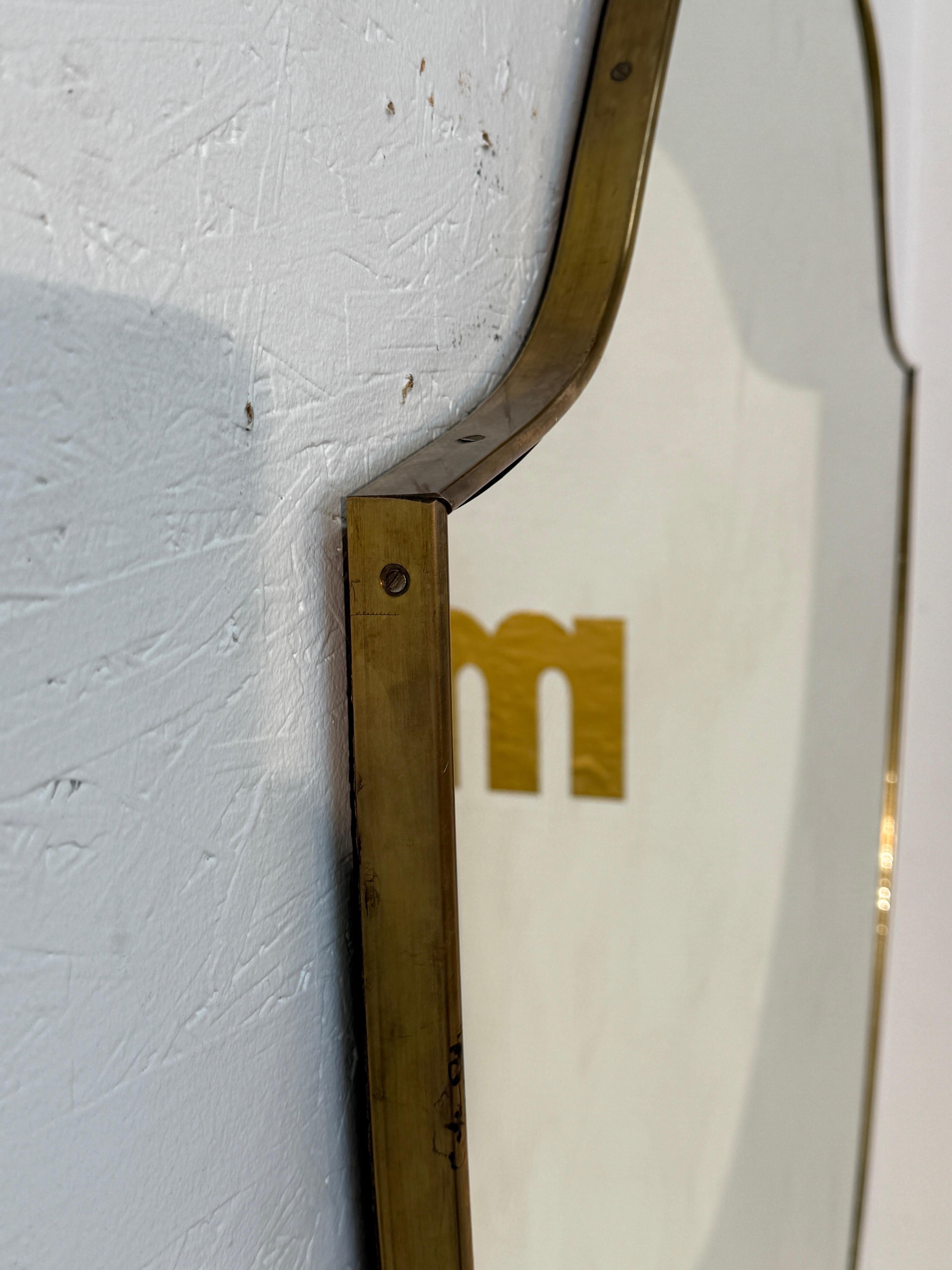Metà XX secolo Specchio da parete a scudo con cornice in ottone, 1950 in vendita
