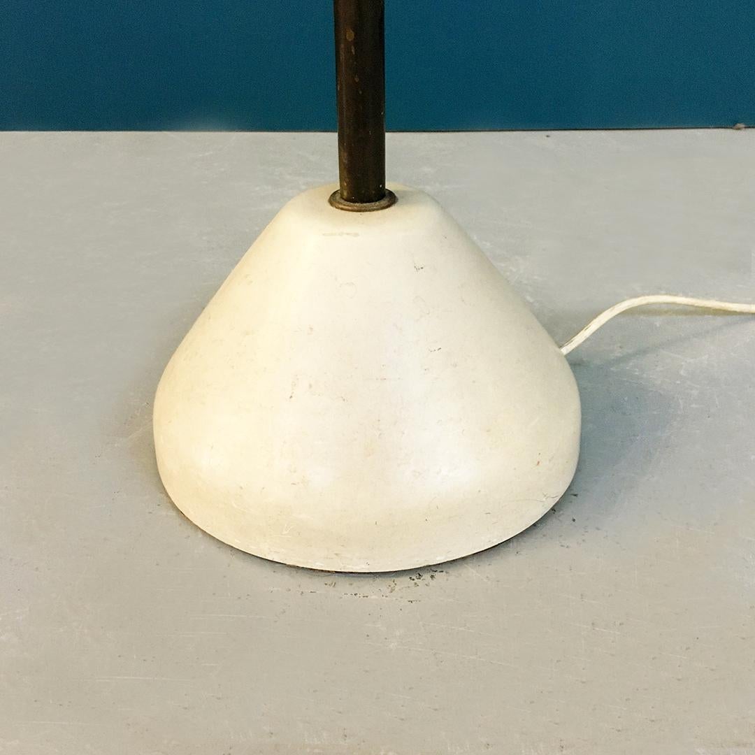 Italian midcentury brass, glass and iron floor lamp, 1950s
Floor lamp with brass stem as well as the cone in which the glass is housed, with a base in white lacquered cast iron.
The glass is original, triplex, opaque white on the outside and