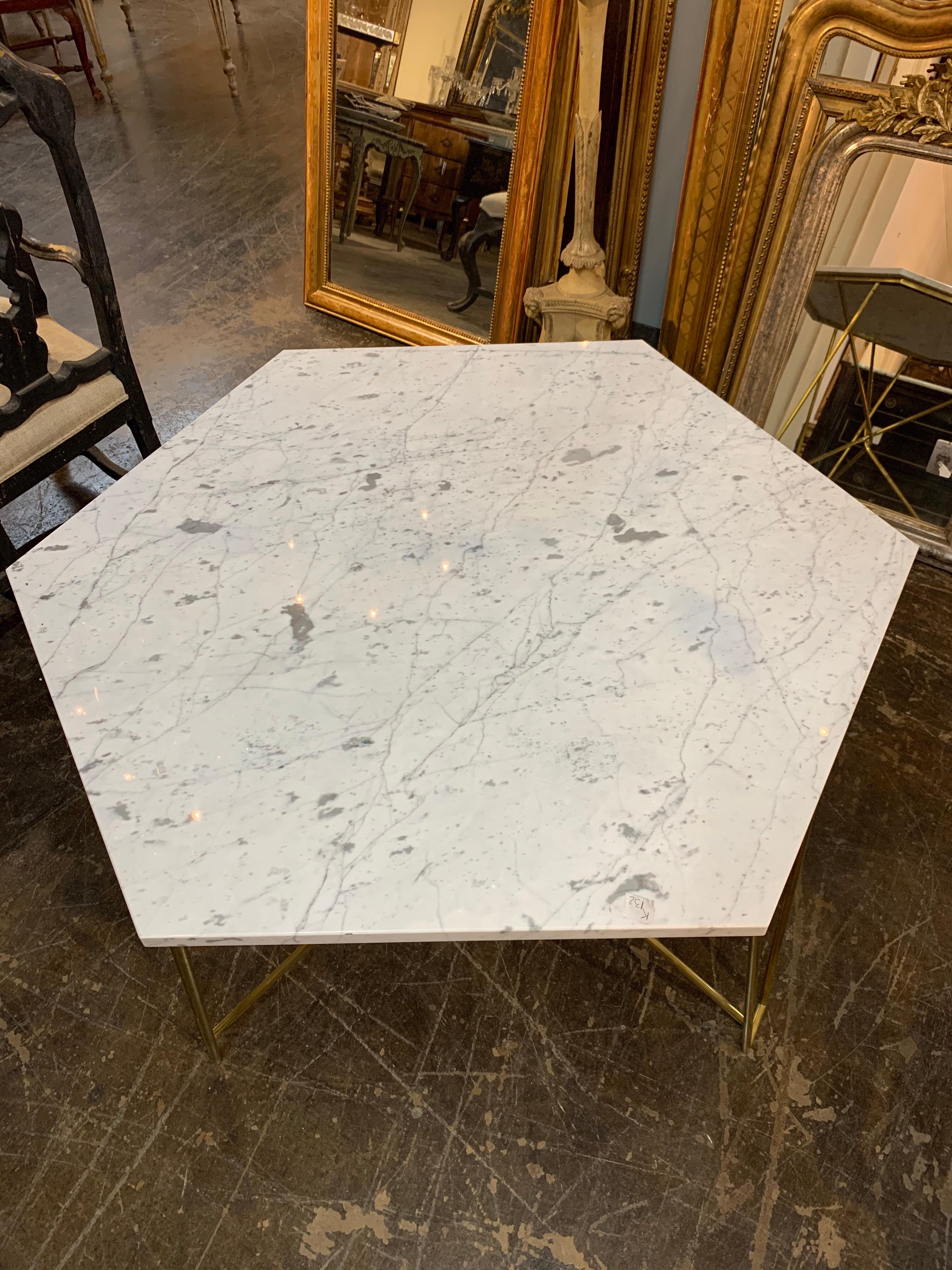 Very sleek Italian midcentury brass hexagonal center table with Carrara marble top. 
The base has interesting intertwined legs and the top is gorgeous. Better hurry. This one won't last long!