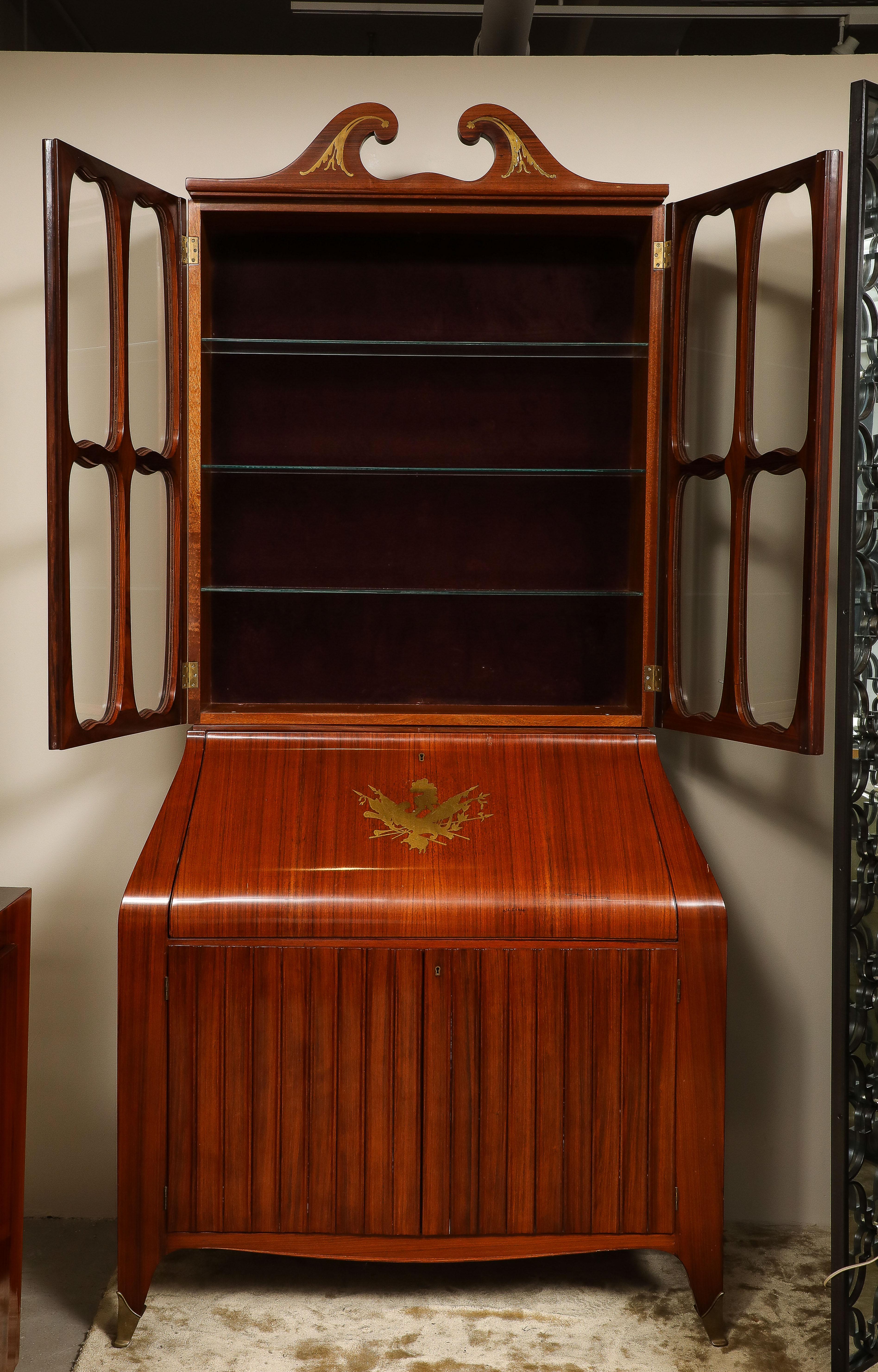 Un bel exemple de secrétaire en bois de rose du milieu du siècle, créé par la designer italienne Paola Buffa (1903-1970), avec des incrustations en laiton de l'artiste Giovanni Gariboldi (1908-1971).
La caisse supérieure présente un fronton brisé
