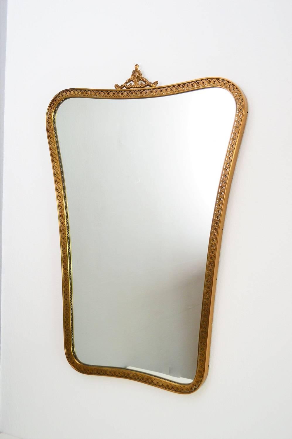 Beautiful wall mirror made in full brass and decorations around the whole frame and on top, typically for the Italian, 1950s.
The mirror glass is in excellent condition.
The frame has a beautiful vintage patina and in excellent condition too.
On