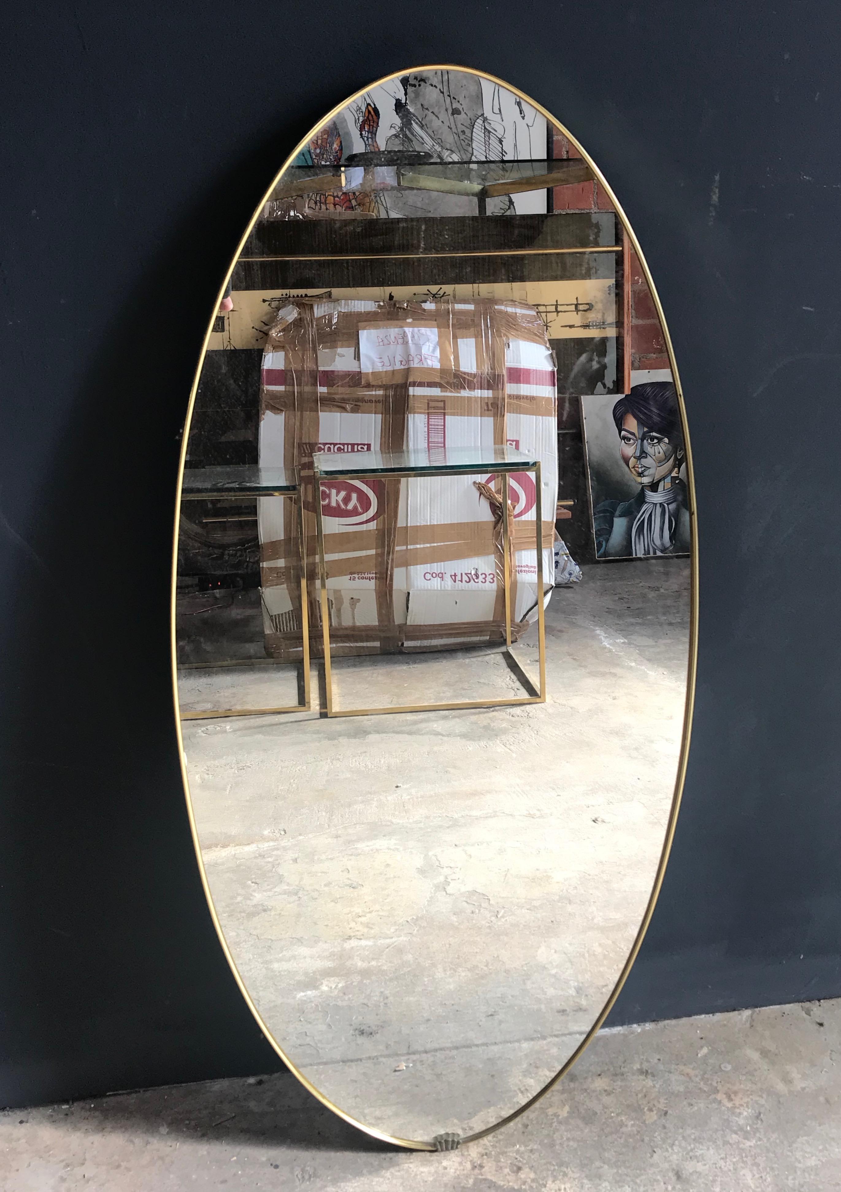 Midcentury brass oval mirror with little shell on the frame, Italy, 1950s.