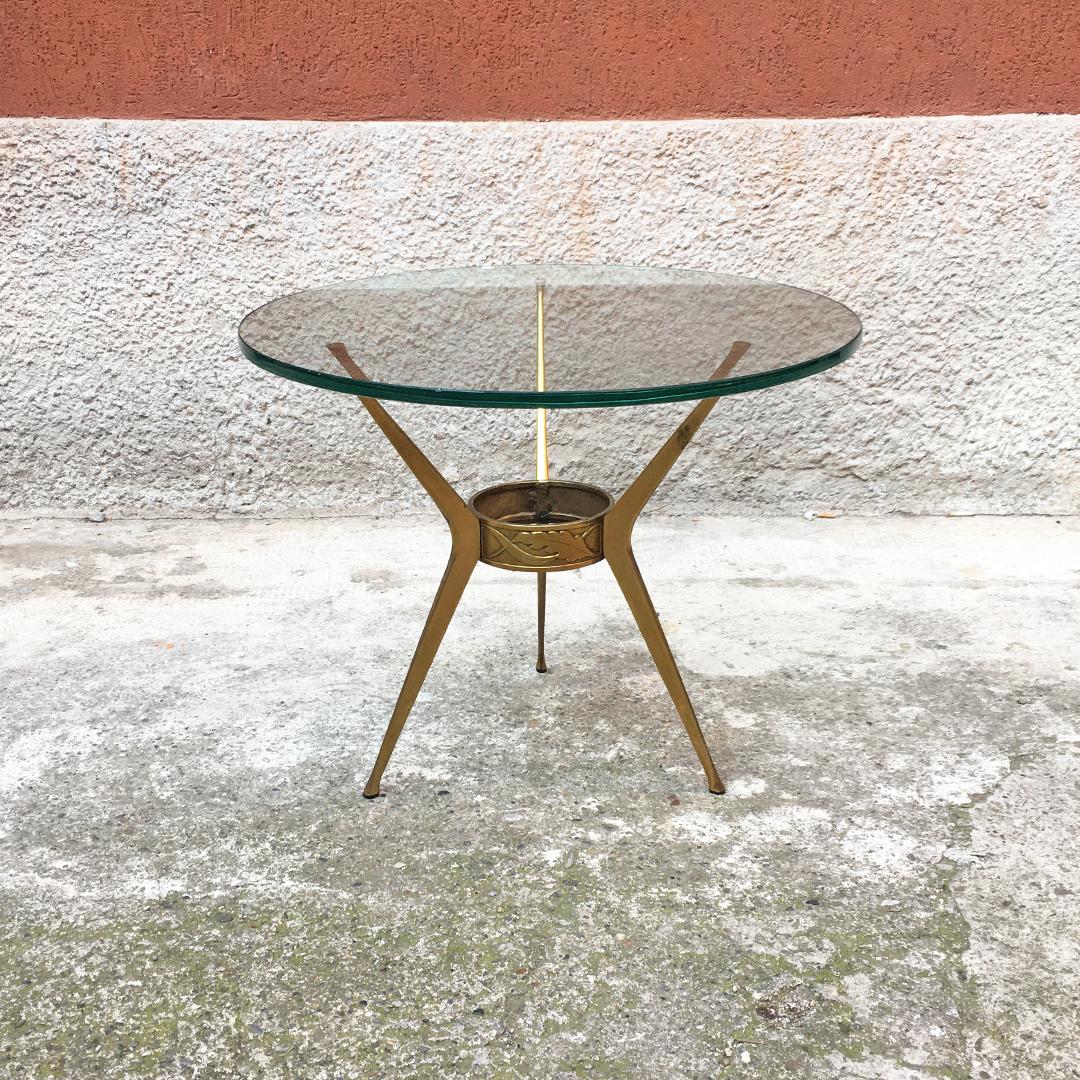 Italian mid-century brass three-legged coffee table with green glass, 1950s
Brass three-legged coffee table with decoration in the central joint ring. The round top is in 12mm aquamarine green glass. Attributed to Cesare Lacca.

Very good general