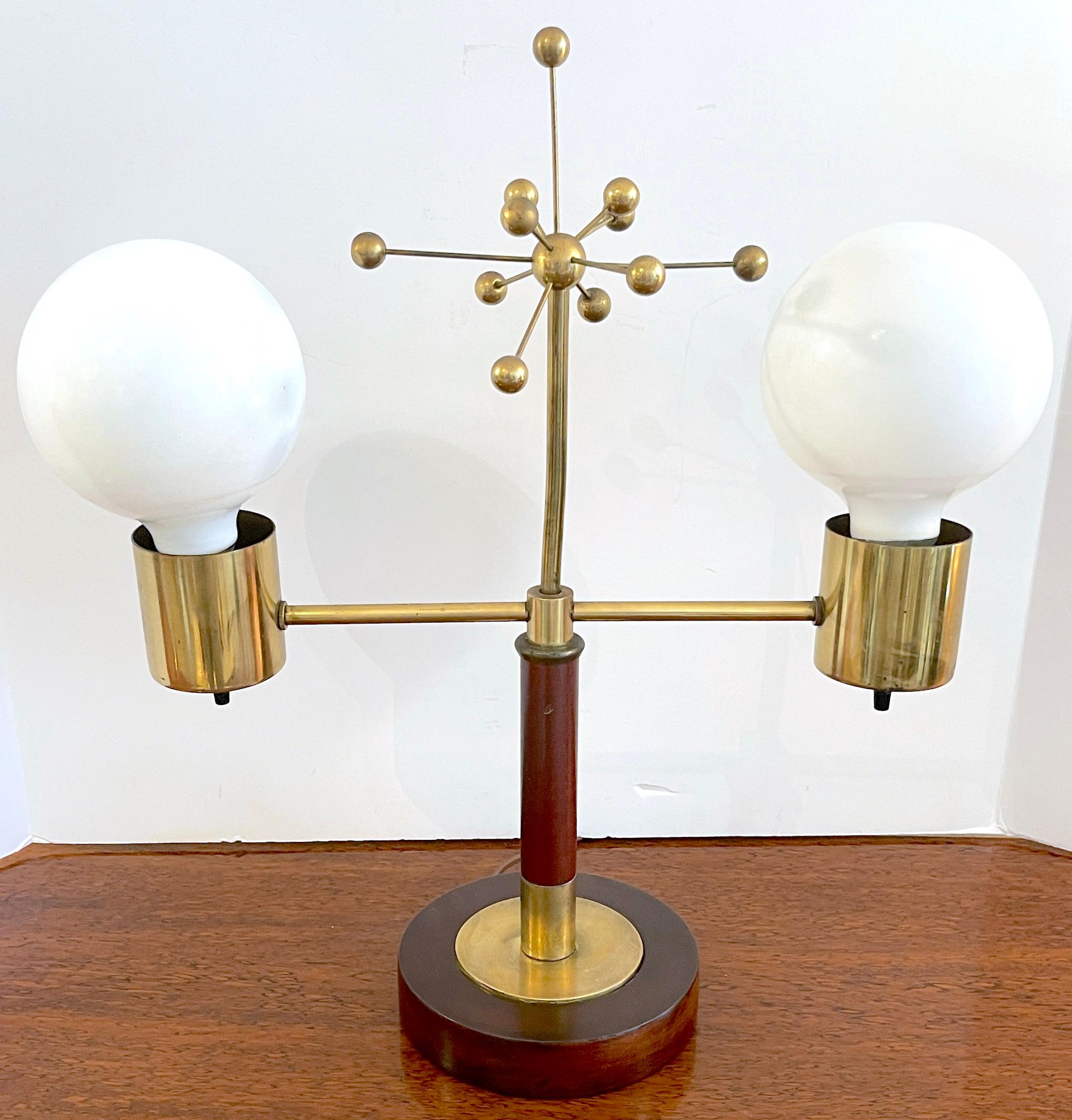Italian mid century brass & wood 'Atomic' lamp 
Italy, 1950s
A unique mid-century lamp, the lamp with a center brass sculpture (Six inch high x 7-inch diameter of a 'Atom Vector' fitted with two straight brass arms. Each arm with a brass electrified