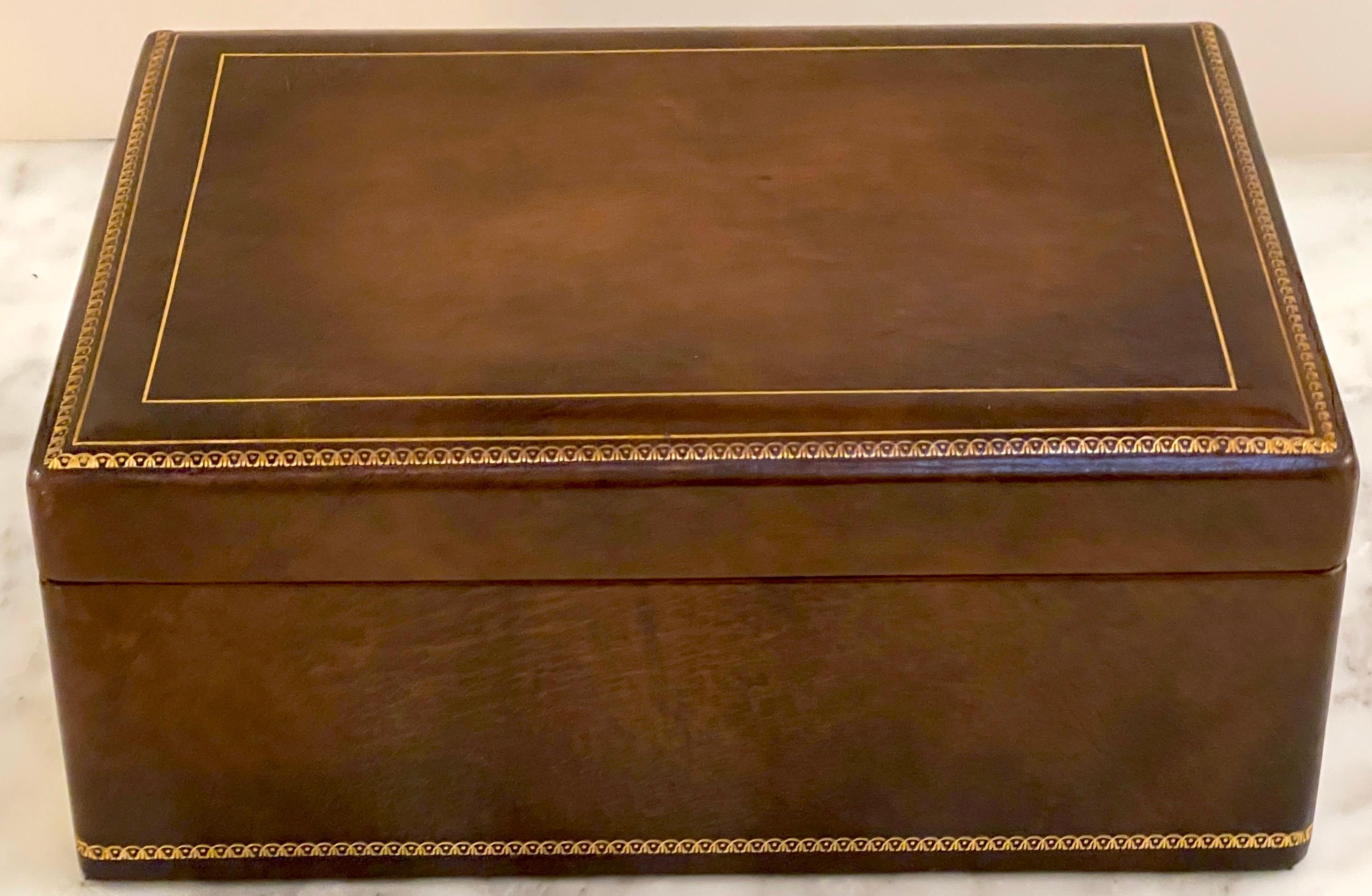 Italian midcentury Brown Leather Neoclassical Humidor with Gilt Tooling 
Italy, circa 1960s

This Italian midcentury brown leather humidor is a sophisticated and functional piece crafted with understated elegance. The rectangular box is made of