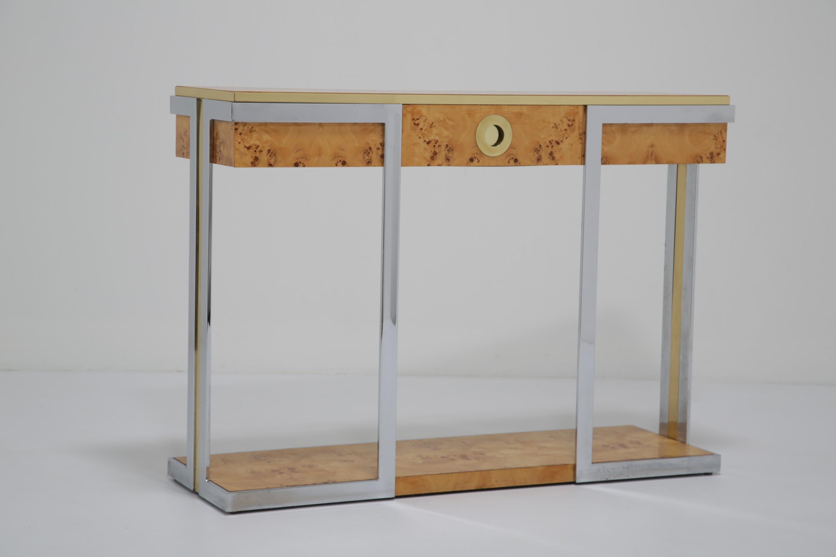 Sicuramente una delle consolle più belle uscite dall'Italia negli anni '70. Una bella forma elegante con un tocco di legno di radica incorniciato da dettagli in ottone e cromo. La console presenta la maniglia circolare dei cassetti firmata Mario