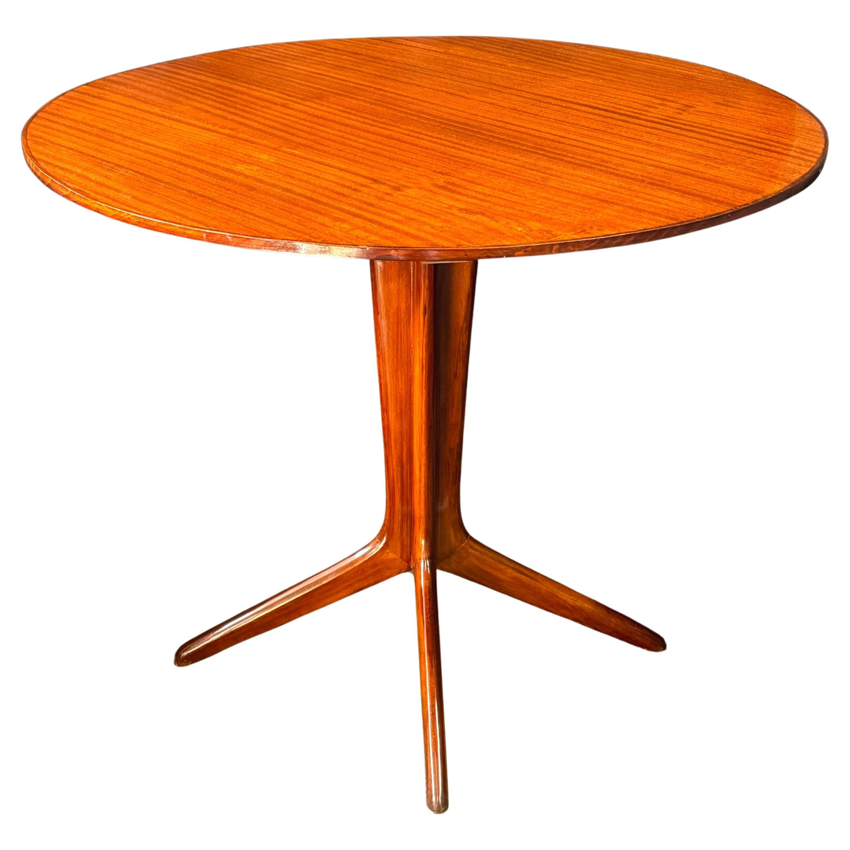 Italian Mid-Century center table attributed to designers Ico and Luisa Parisi with a beautifully grained walnut top having delicate inlay around the outer edge. The iconic pedestal base splays stylishly into four tapered legs. 

The table measures