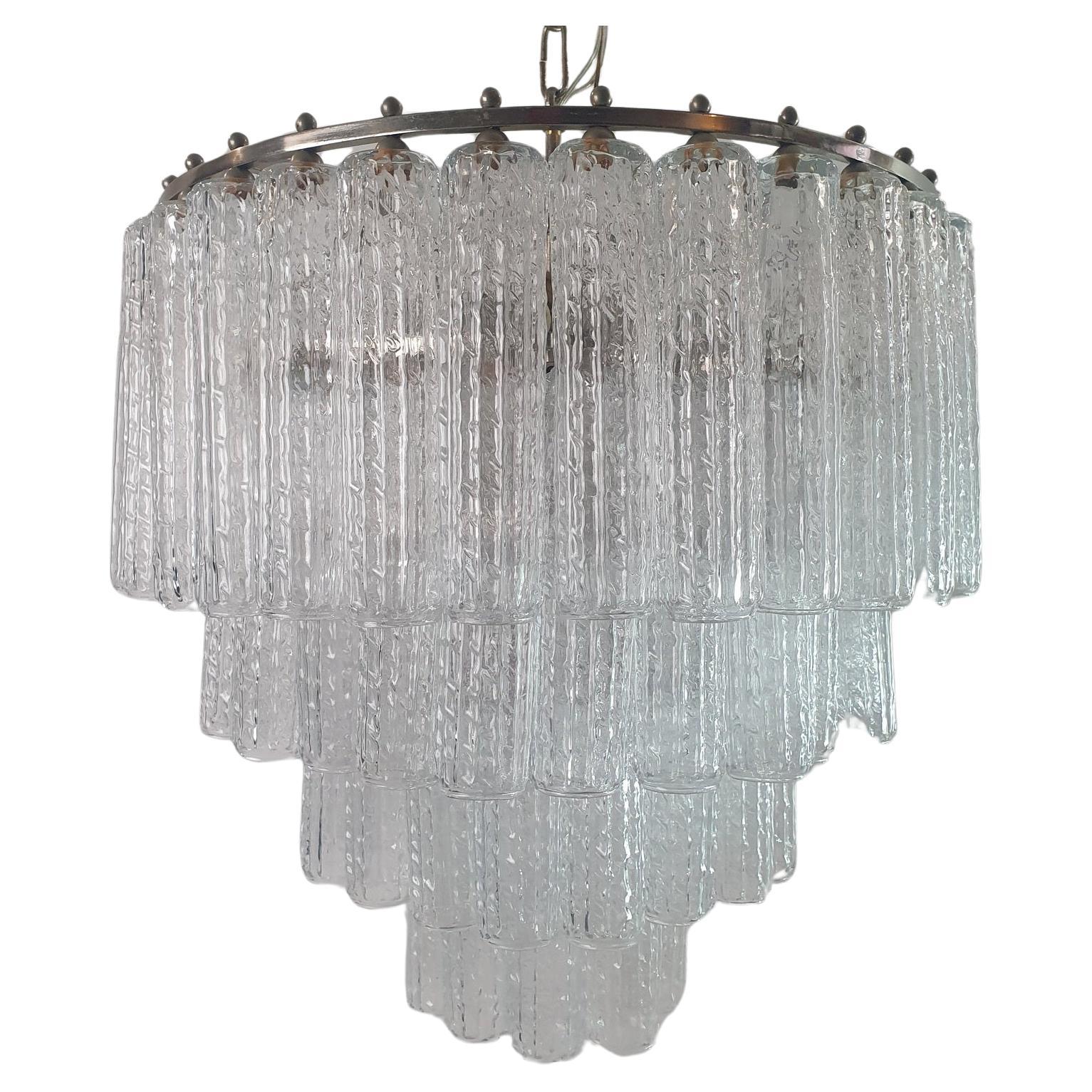 Un lampadario di metà secolo con tubi in vetro di Murano trasparente che scendono a cascata da una struttura in metallo. In ottime condizioni.
Lunghezza totale con catena 100 cm, che può essere allungata su richiesta. Solo la lampada misura 50 cm di