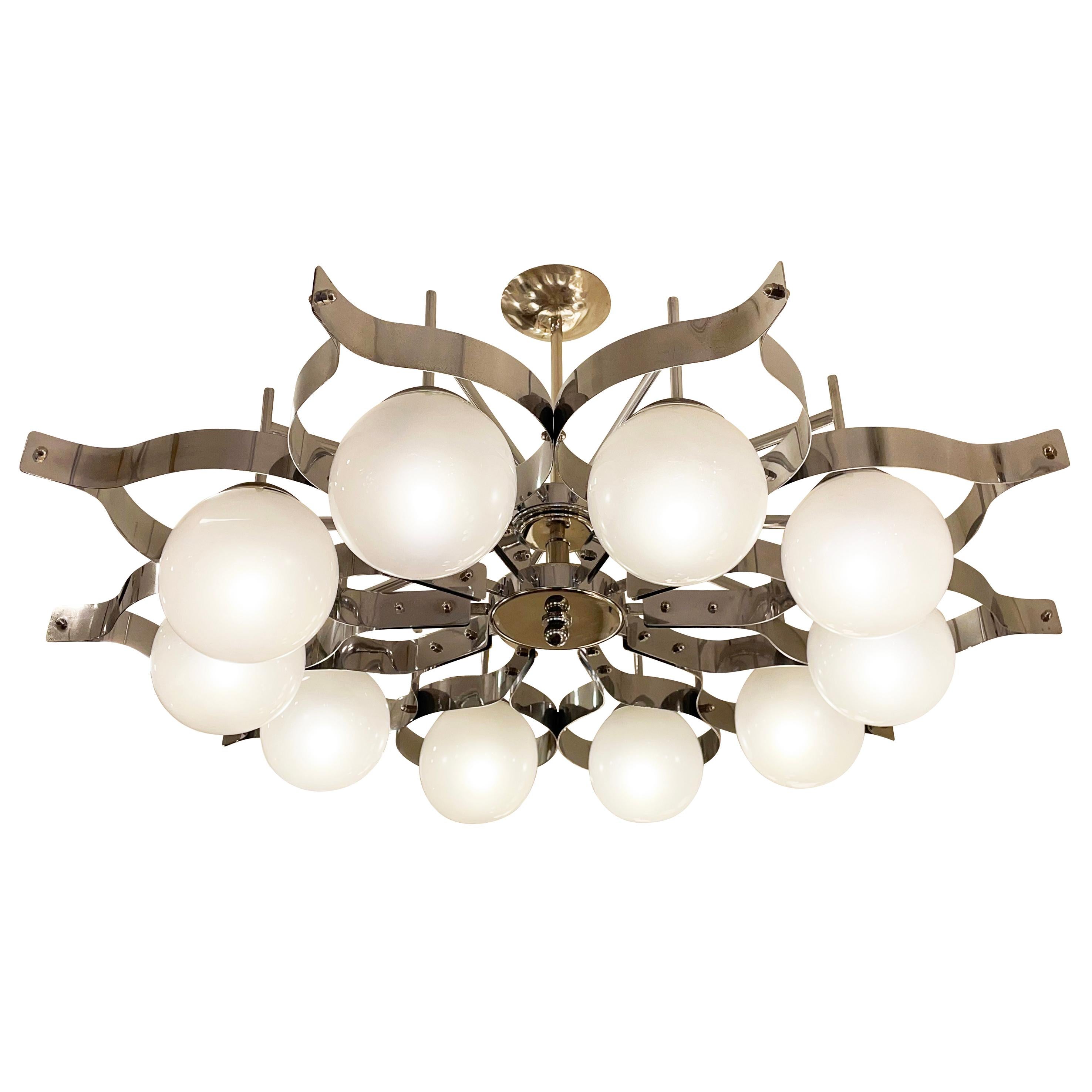 Italian Mid-Century chandelier in the manner of the “Pavone” designed by Gio Ponti for Arredoluce. The intricate frame is in polished nickel and holds ten pearlized glass shades.

Condition: Good vintage condition, minor wear consistent with age