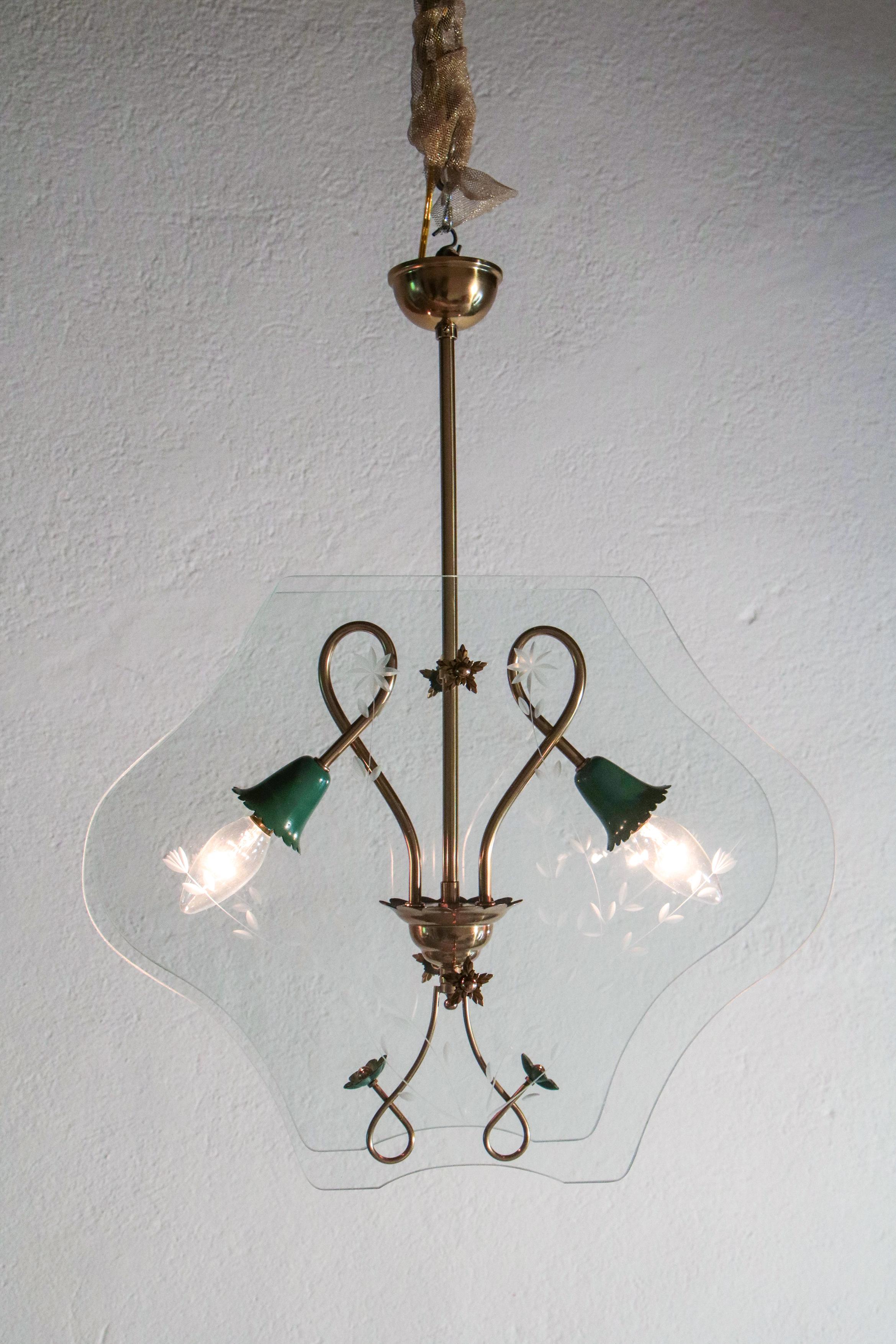 Elegant and stylish Italian mid-century chandelier of Pietro Chiesa per Fontana Arte, from the 1940s.
Two lights, polished brass structure, green aluminum lamp holder, and floral print glasses. The restoration was made with great care by a