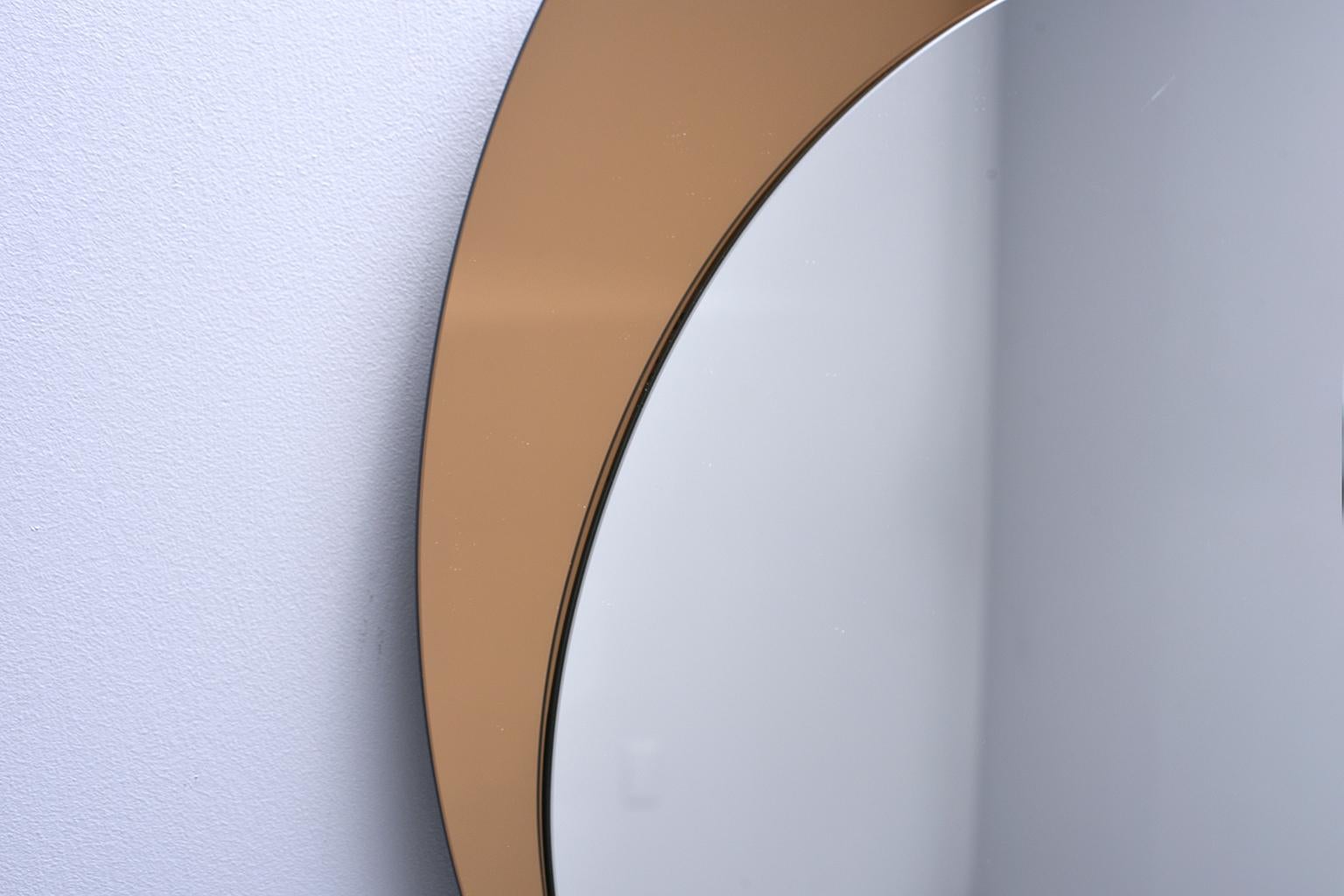 Italian mirror features a bronze colored circular mirror with off-center silver mirror overlay. Unknown maker. Very good vintage condition, circa 1970s.

Inner silver mirror size 23.5