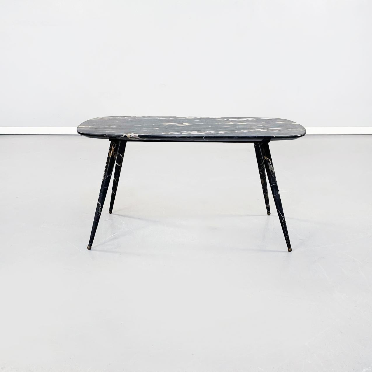 Italian mid-century coffee table in black Portoro marble, 1960s
Coffee table with rectangular top with rounded corners in Portoro marble. The top is supported by a metal structure that joins the 4 round legs in Portoro marble. The feet are round