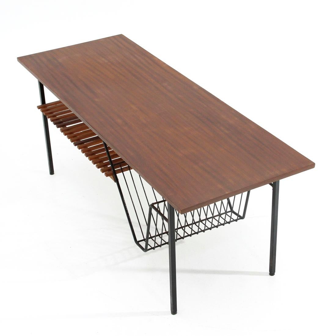 Italian-made coffee table produced in the 1960s.
Structure in black painted metal.
Top in teak veneered wood.
Lower shelf in teak slats.
Rubber feet.
Good general conditions, some signs due to normal use over time.

Dimensions: Length 110 cm,