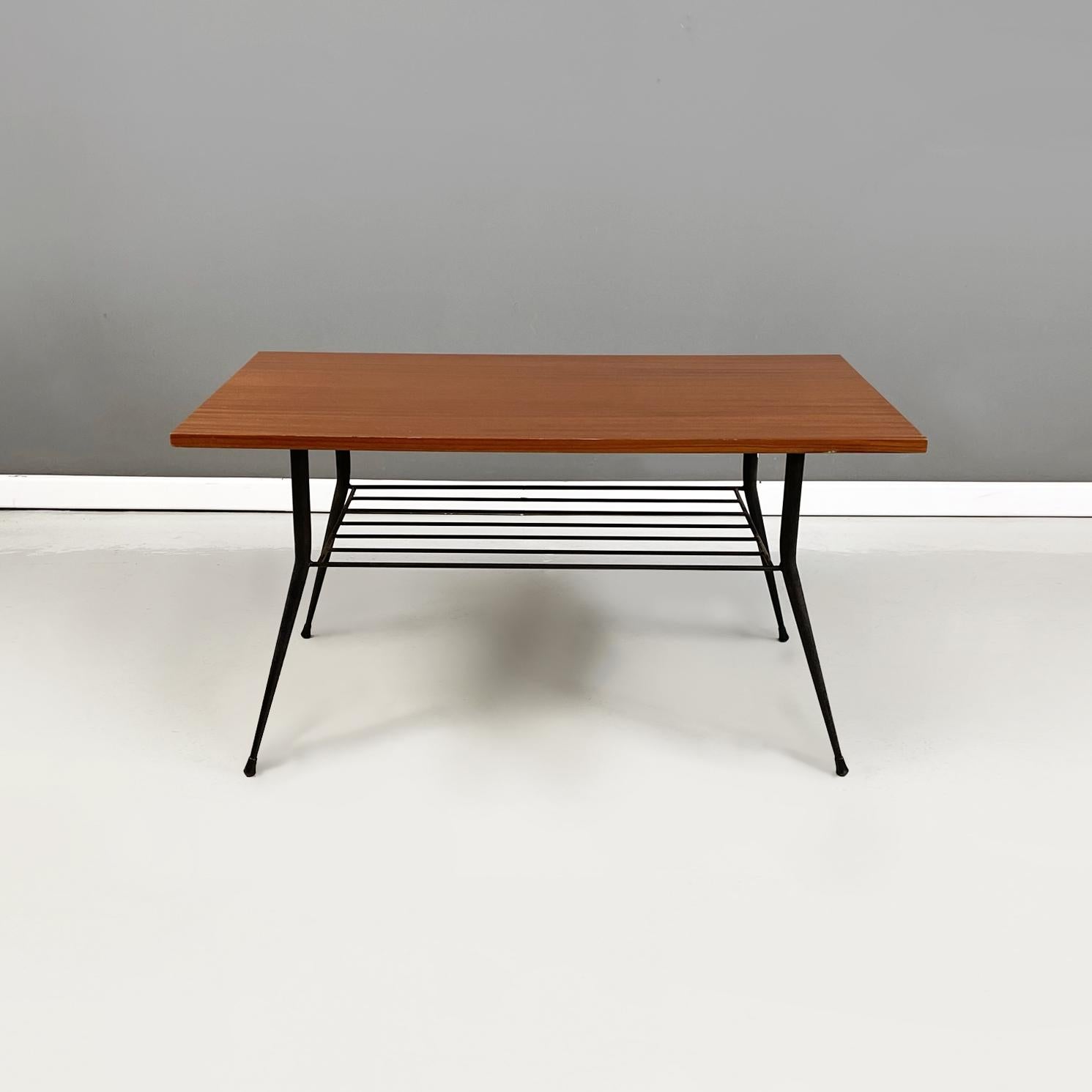 Italian mid-century Coffee table with magazine rack in wood and metal, 1960s
Coffee table with rectangular wooden top. Under the top there is a magazine rack in black metal rod. Legs in black metal rod with round feet.
1960s.
Good condition, the