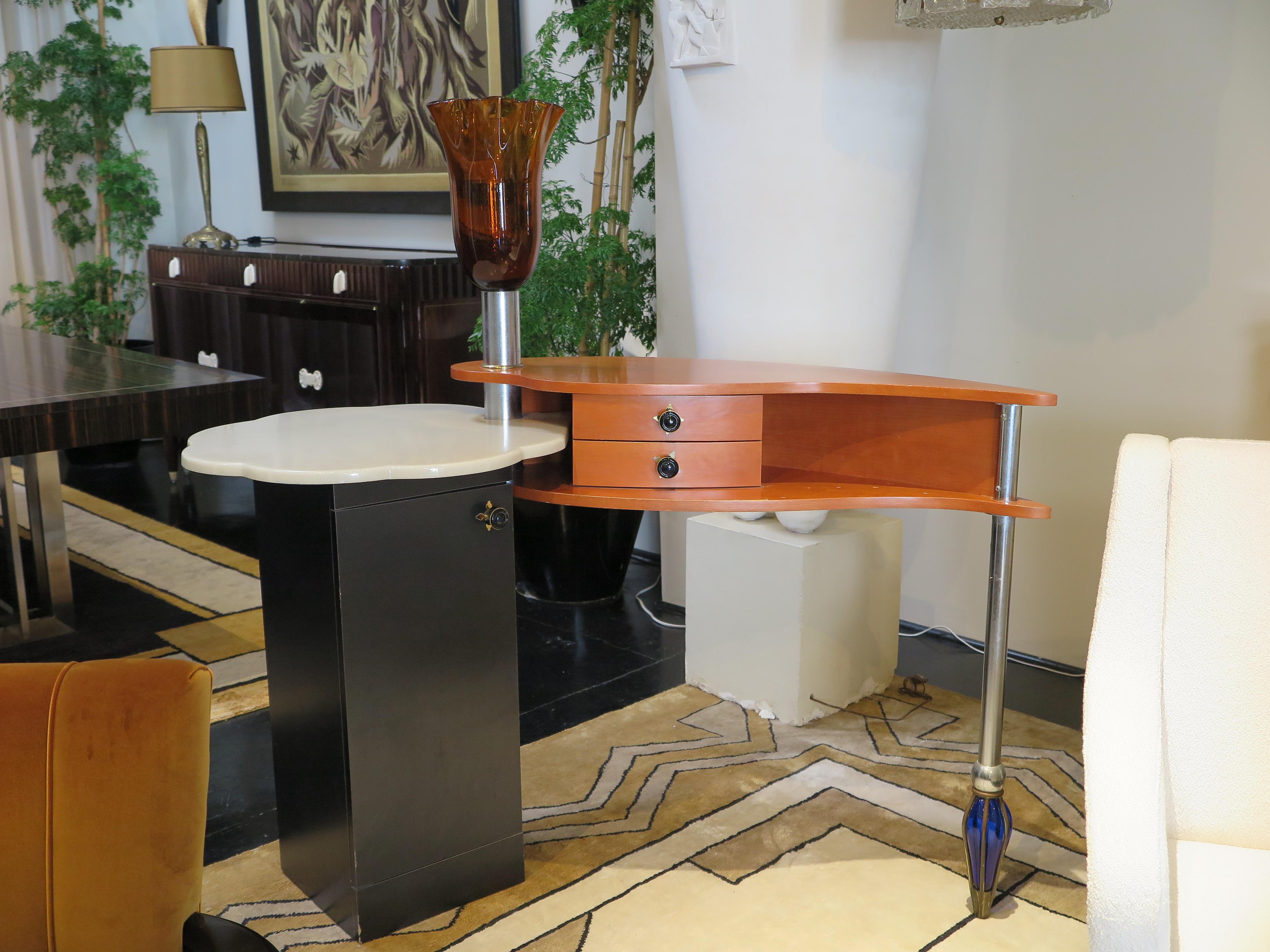 Italian Mid-Century console/occasional table with curved cherry wood desk top adjoined by a scalloped white granite on an anthracite lacquer pedestal base with storage. A hand-blown orange tulip glass joins the two-tired table top. A blue glass