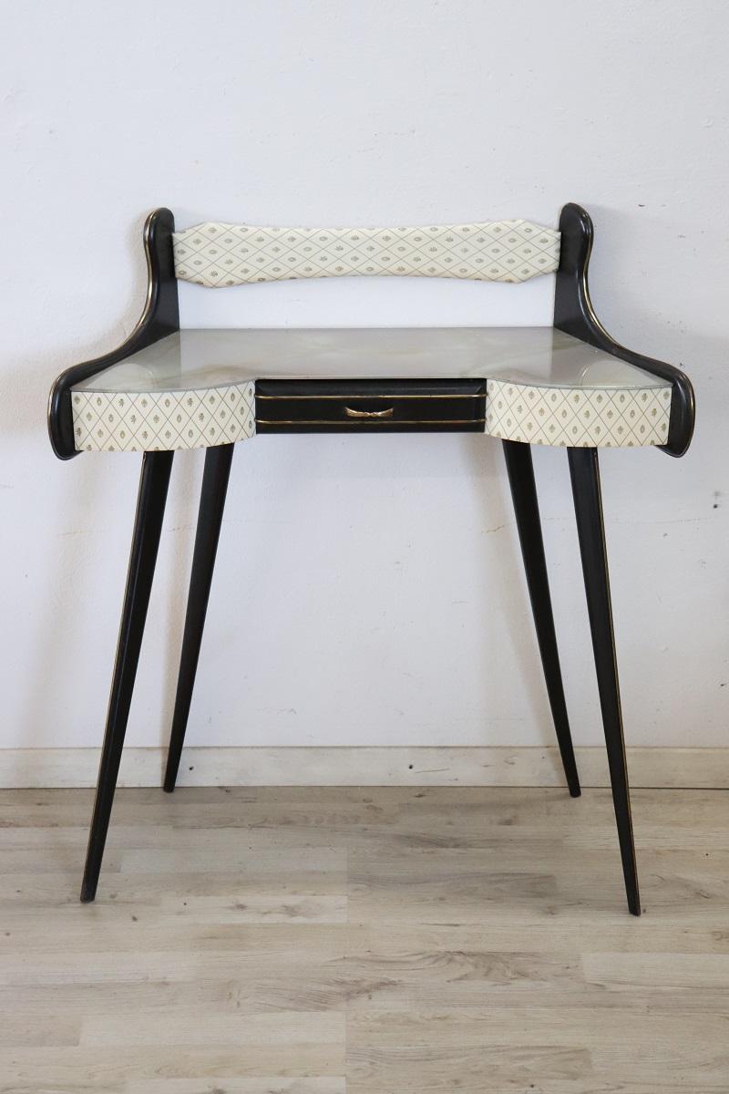 This Italian design console table from 1950 is truly special. Made of black lacquered wood with a wavy line on the front. Equipped with a practical drawer. The top is in decorated glass. The front is covered in plastic with printed decoration.
