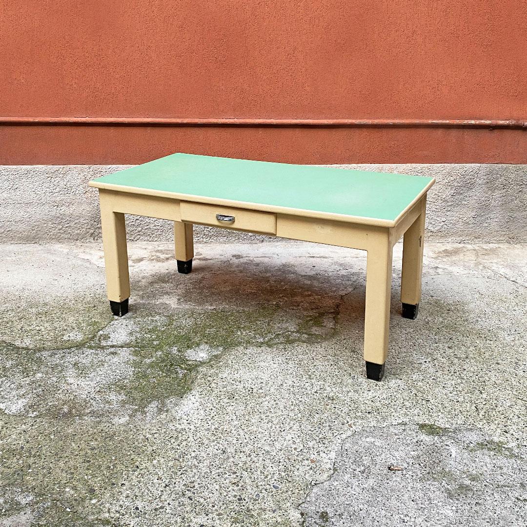 Italian mid century creamy white wood and aquamarine formica kitchen table, 1940s
Kitchen table, in creamy white enamelled wood, with aqua green formica top and drawer with metal handle. Square section legs, with black painted