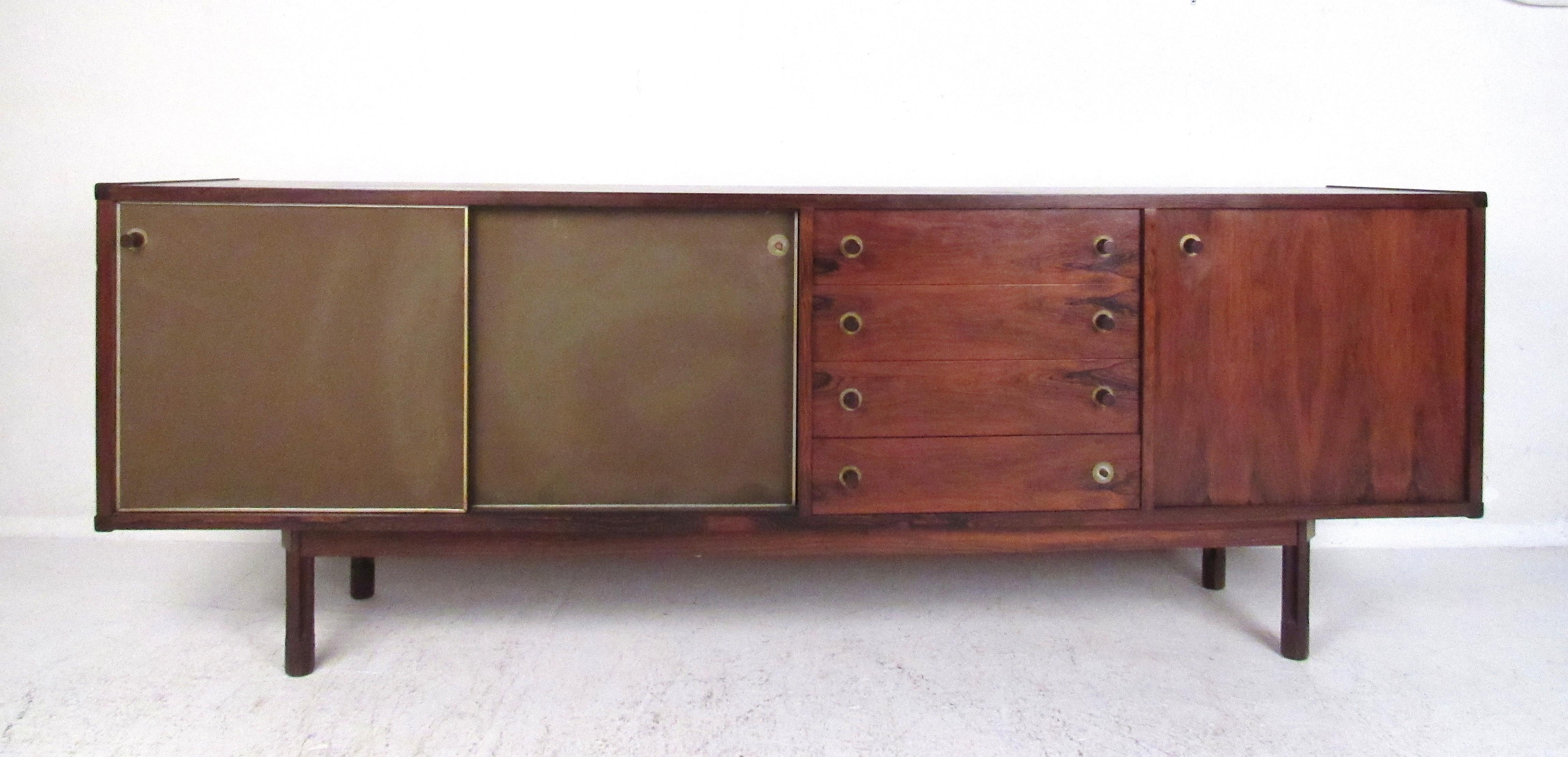 Beautiful midcentury Italian credenza or sideboard covered in a rich rosewood veneer. Sliding cabinet doors along with four drawers in the center offer ample room for storage. The piece's finished back allows it to be admired from all angles. Please