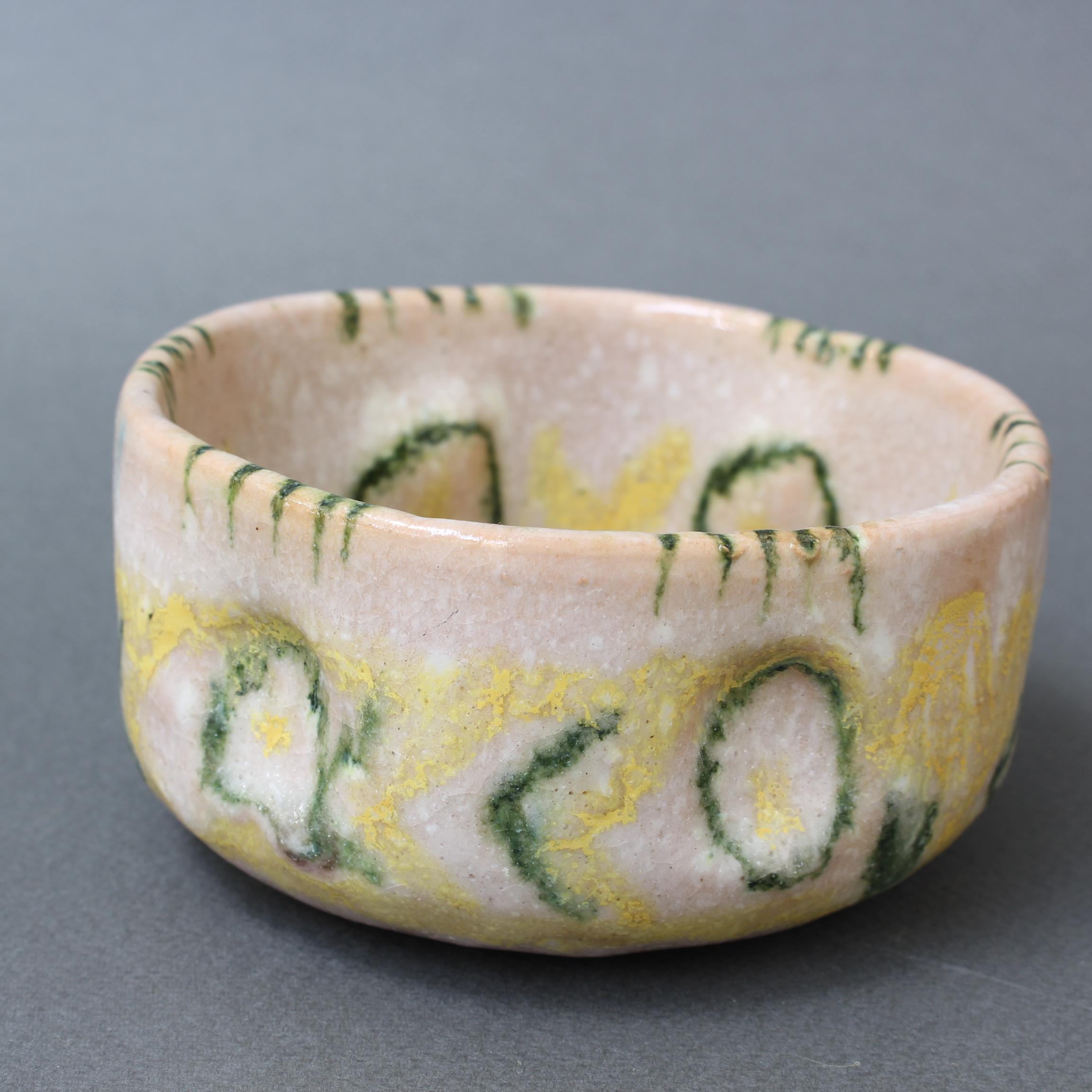 Small decorative Italian ceramic bowl by Guido Gambone (circa 1950s). Decorated on the inside with stylised yellow and green lemon wedges and flowers, the outer surface presents amorphous shapes in the same colors. The small bowl is utterly charming