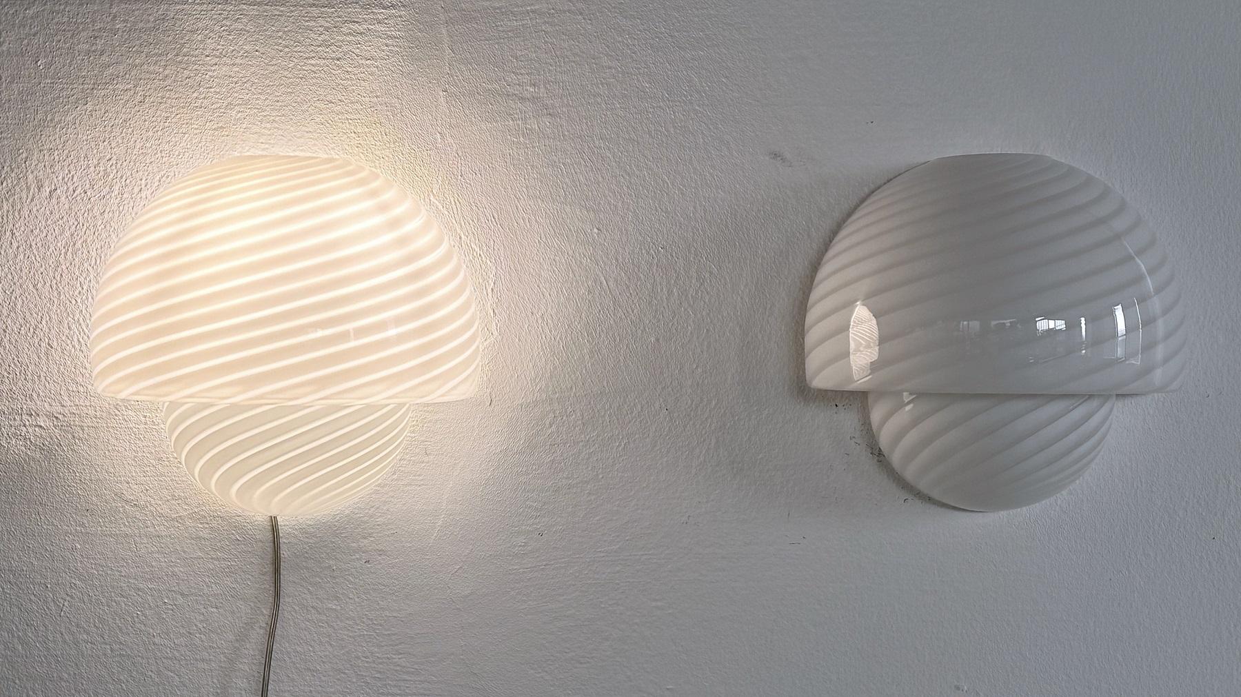 Gorgeous pair of Murano glass wall sconces Made in Italy by De Majo Murano during the 1970s.
Every glass is signed by hand ( see detail picture)
This beautiful pair of shiny white swirl glass is hand-crafted and in mint condition. The swirl glasses