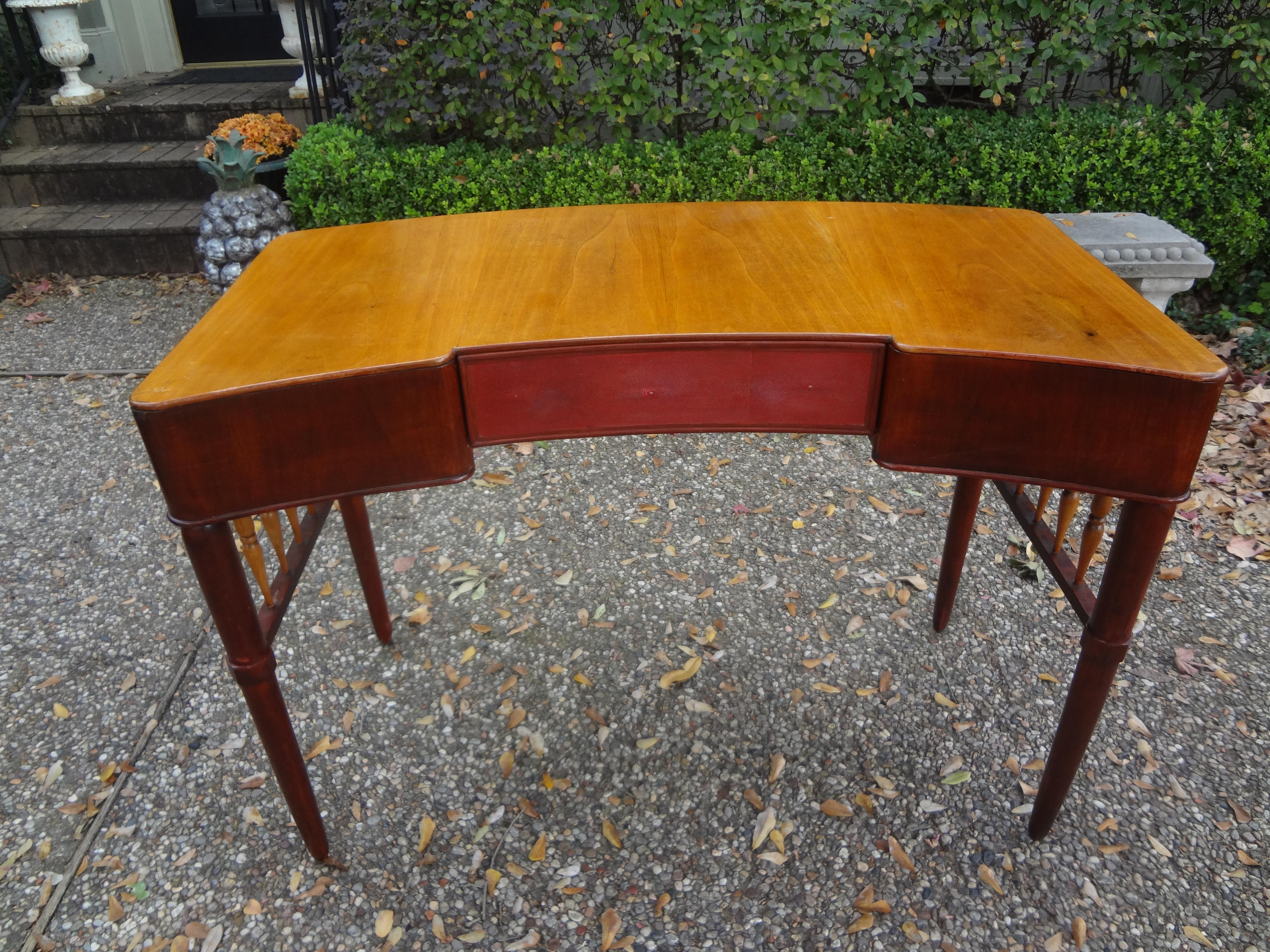 Stunning Italian mid-century desk or writing table attributed to Paolo Buffa. This sculptural desk has beautifully tapered legs, two side drawers and a shagreen covered center drawer. This lovely piece is finished on all sides could be floated in a