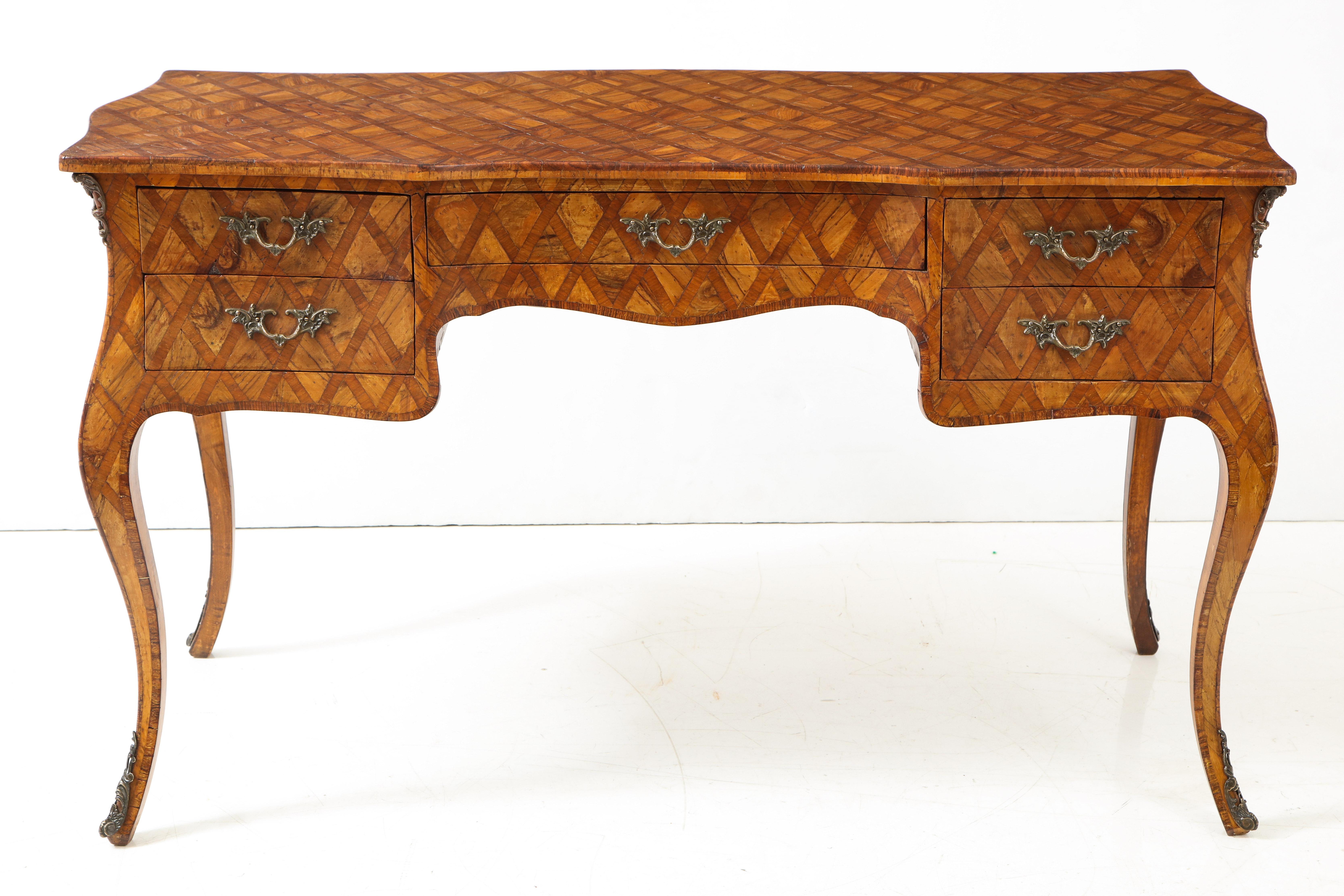 A striking Italian walnut desk with a beautiful inlaid diamond pattern, raised on cabriolet legs. This unique piece features bronze hardware and five drawers.