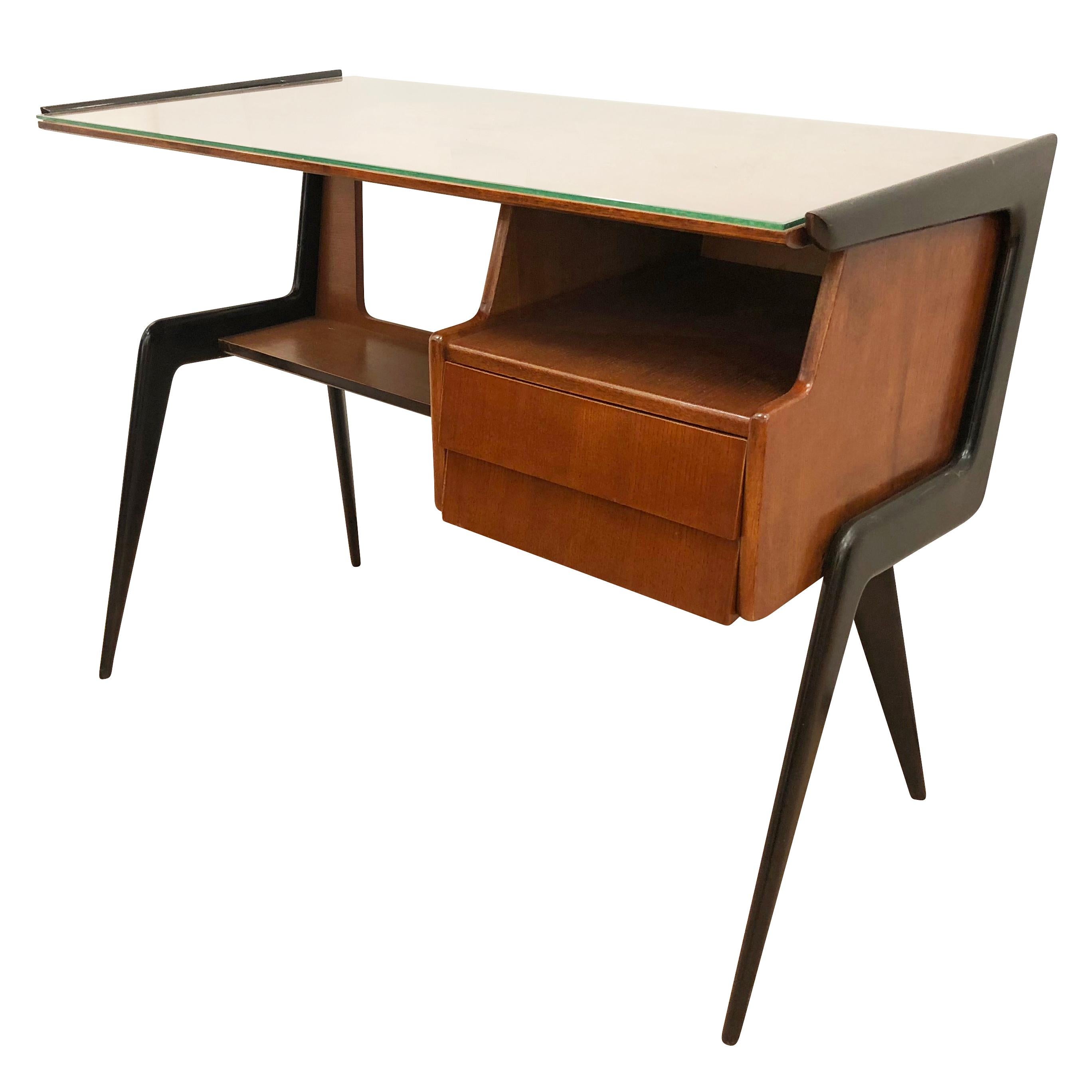 Beautiful Italian midcentury desk in the manner of Silvio Cavatorta. Walnut body with ebonized legs. Has a clear glass top and two drawers.

Condition: Excellent vintage condition, minor wear consistent with age and use. Recently