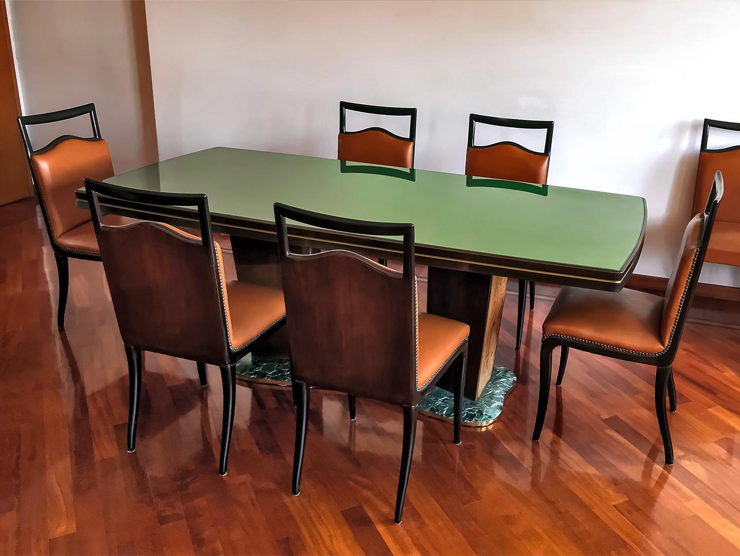 For your consideration this elegant dining room set in Art Deco style, designed by Vittorio Dassi in the 1950s, composed by dining Table with its Chairs (set of 8).
The top-table has a glass back-treated with green colored paper and is supported by