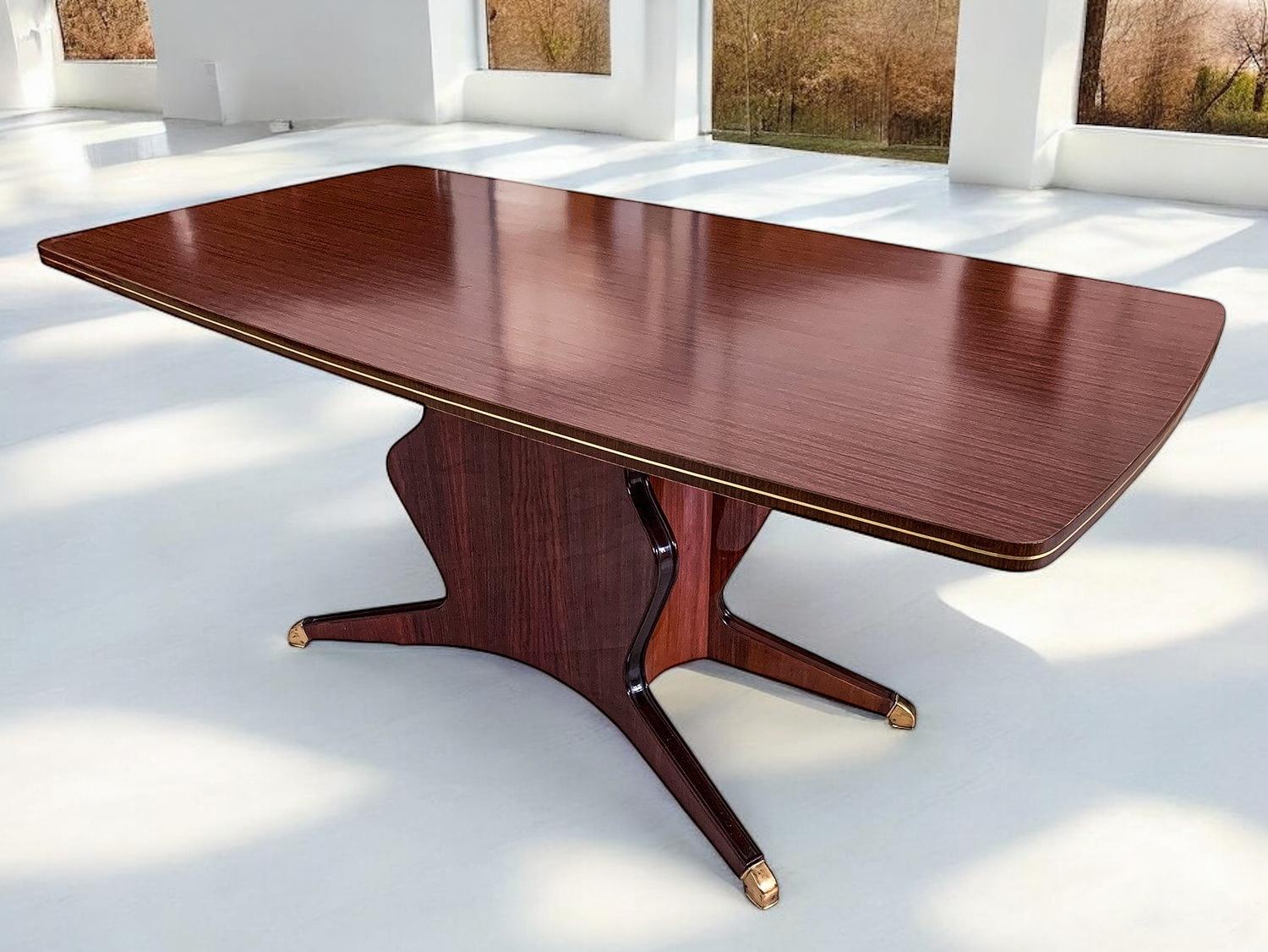 Der stilvolle Esstisch von Osvaldo Borsani ist ein echtes Statement und ein großartiges Beispiel für das italienische Design der 1950er Jahre.
Seine Struktur zeichnet sich durch ein einzigartiges Formdesign aus, das mit Messingfüßen und einer